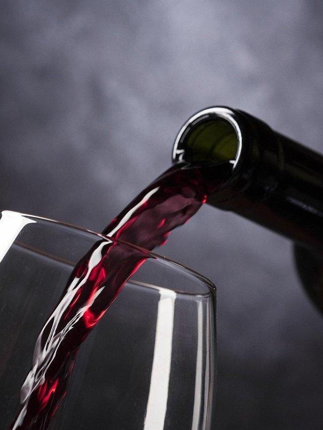 Du vin est servi dans un verre à pied.