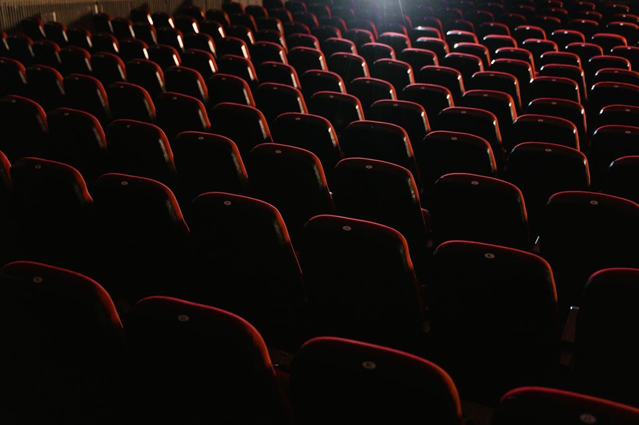 Sièges dans une salle de cinéma plongée dans le noir.