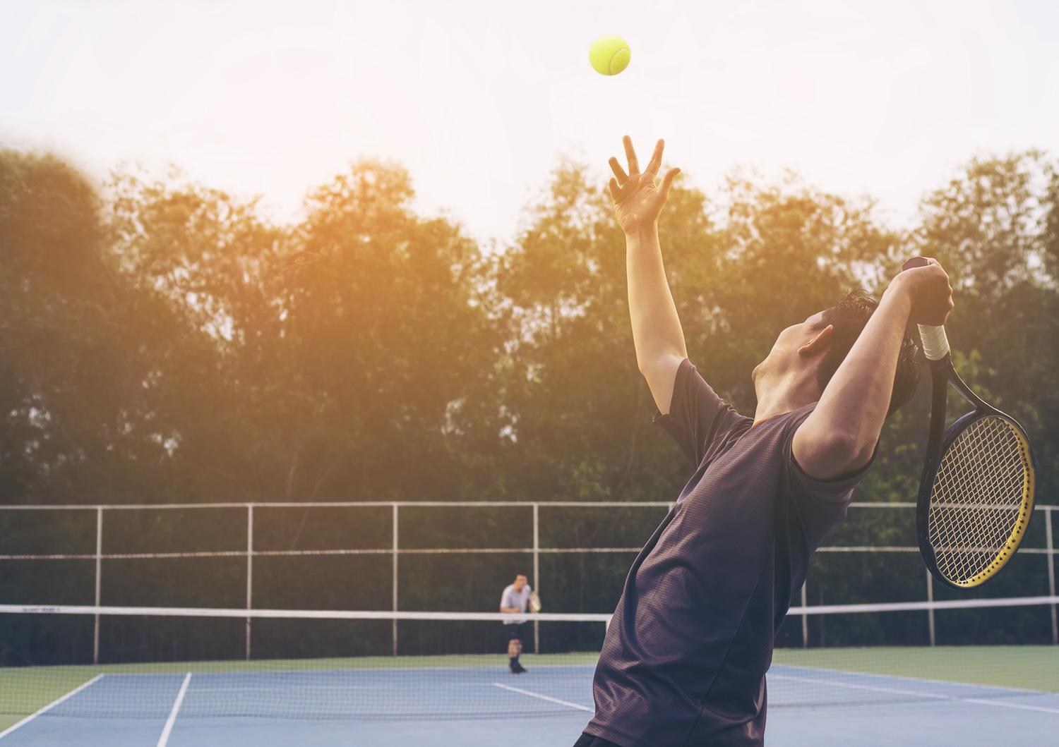 Un joueur de tennis est en train de faire un service.