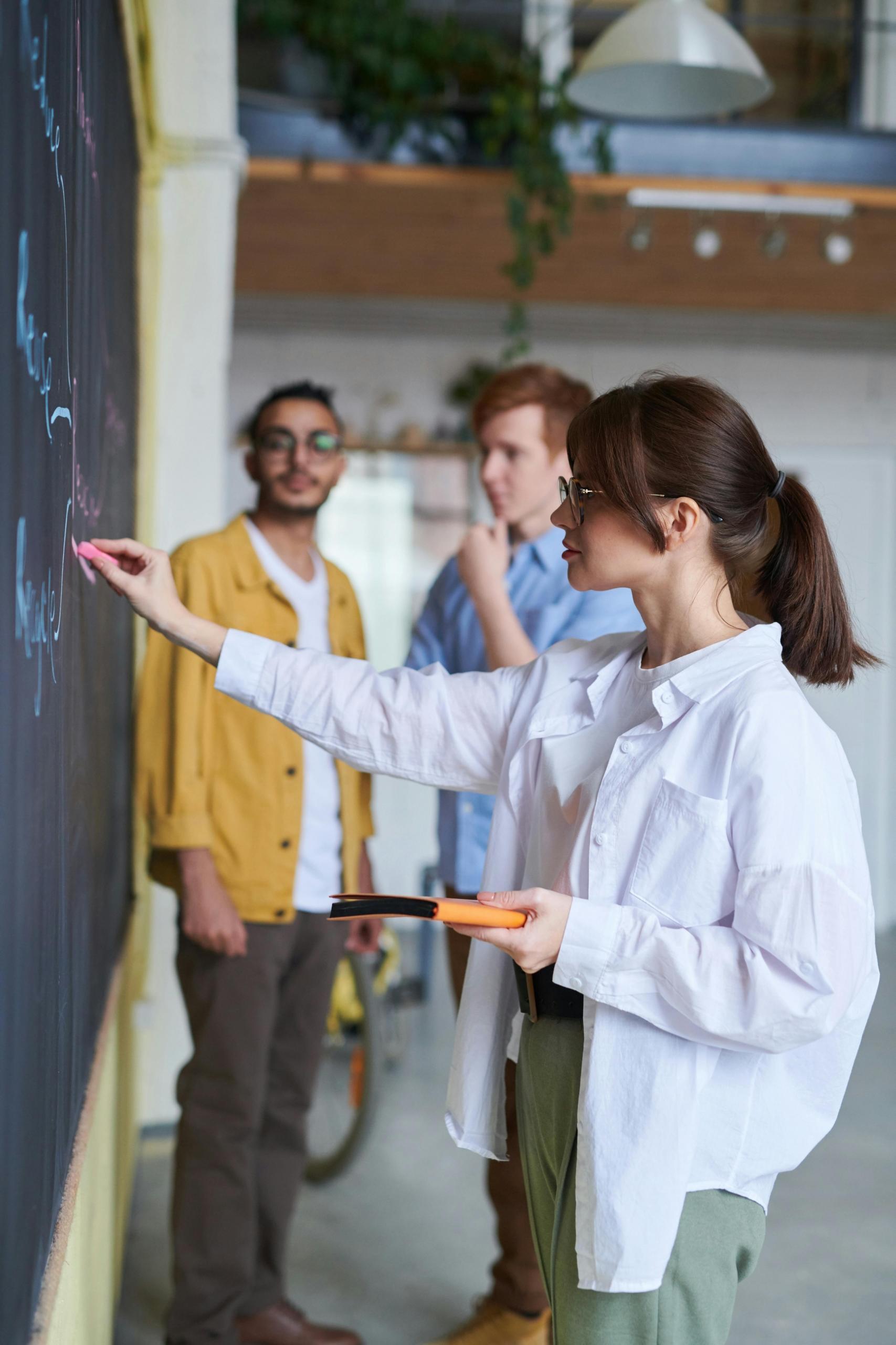 Une élève réalise des calculs au tableau.