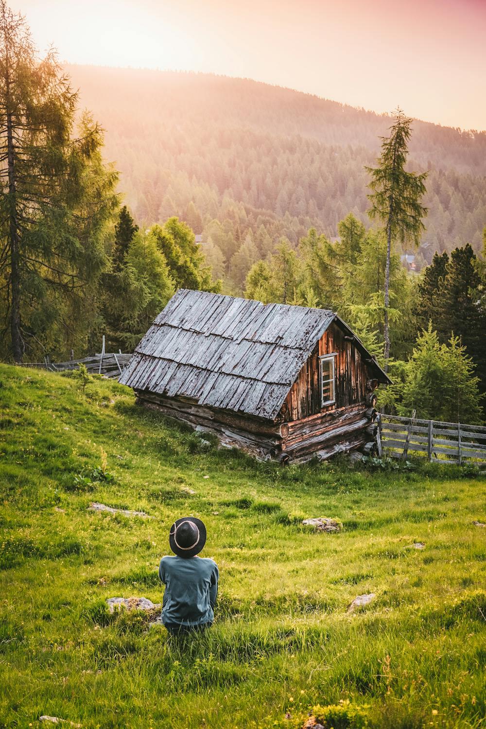 Une personne est assise près d'une maison en pleine campagne.