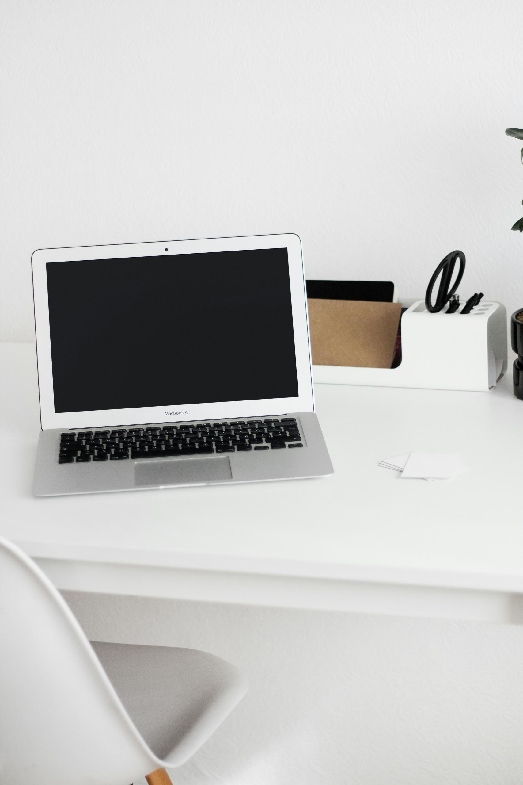 Un ordinateur portable posé sur un bureau blanc.