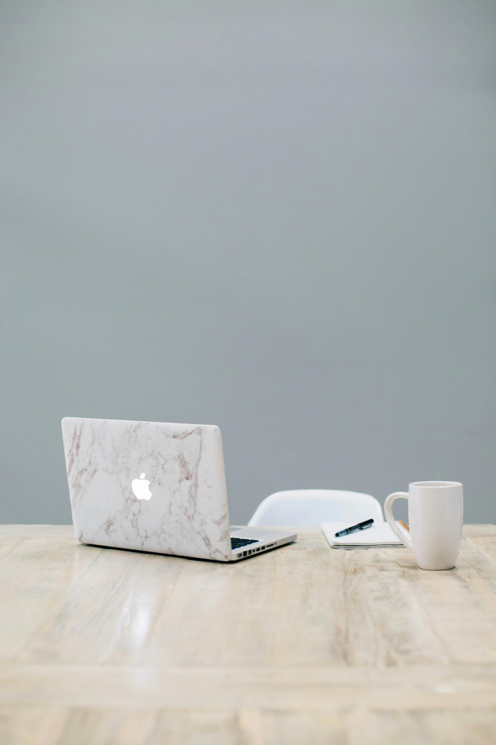 Un bureau de travail avec un ordinateur portable et une tasse.