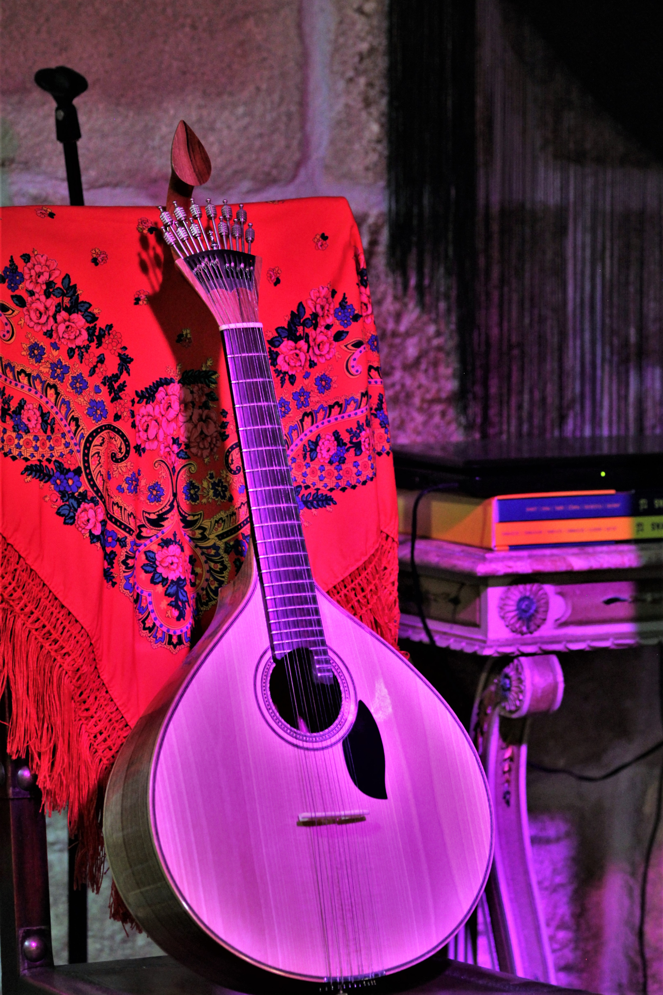 Une guitare portugaise posée sur une chaise.