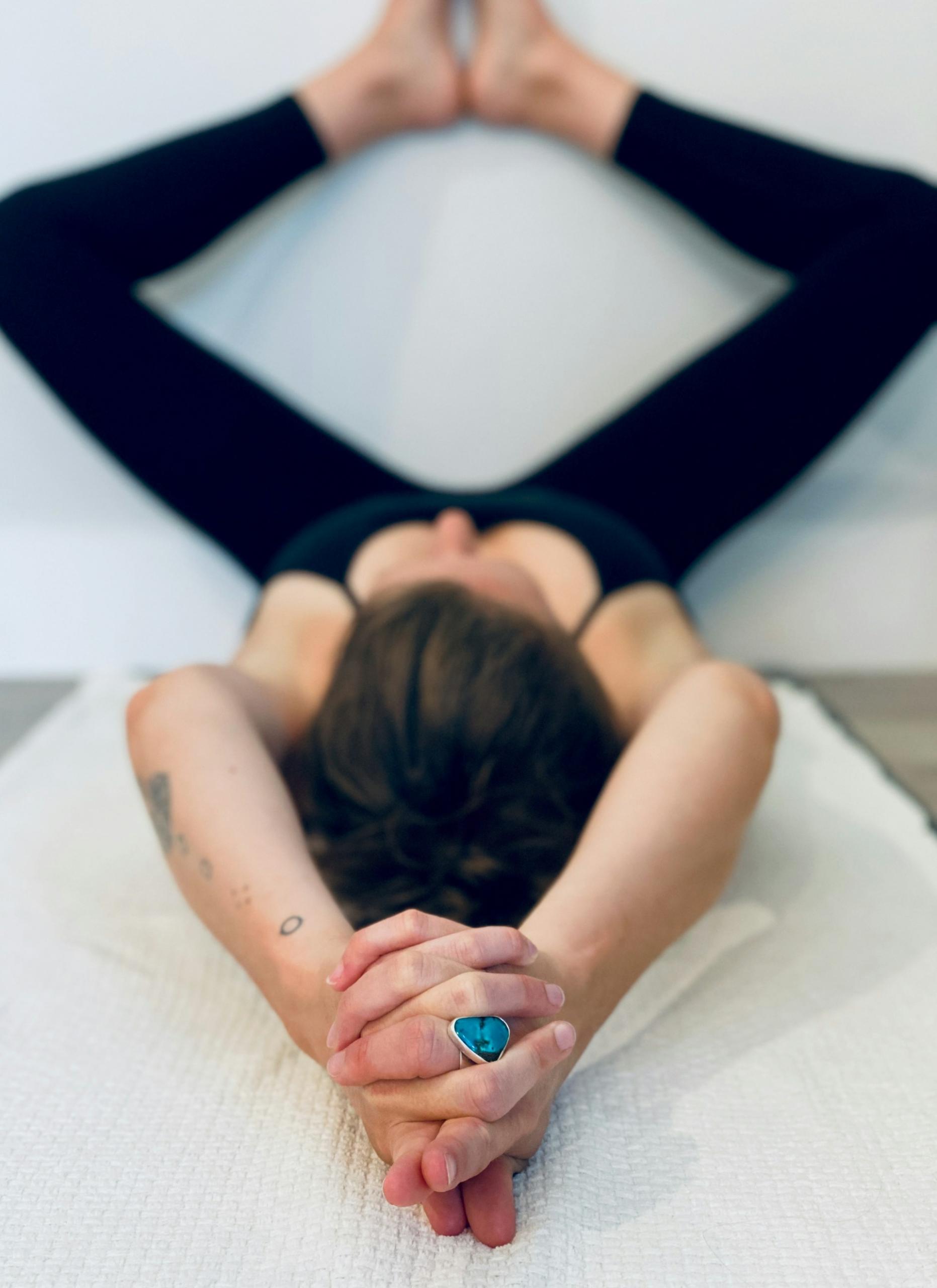 personne en tenue de sport en train de faire une posture de yoga contre un mur