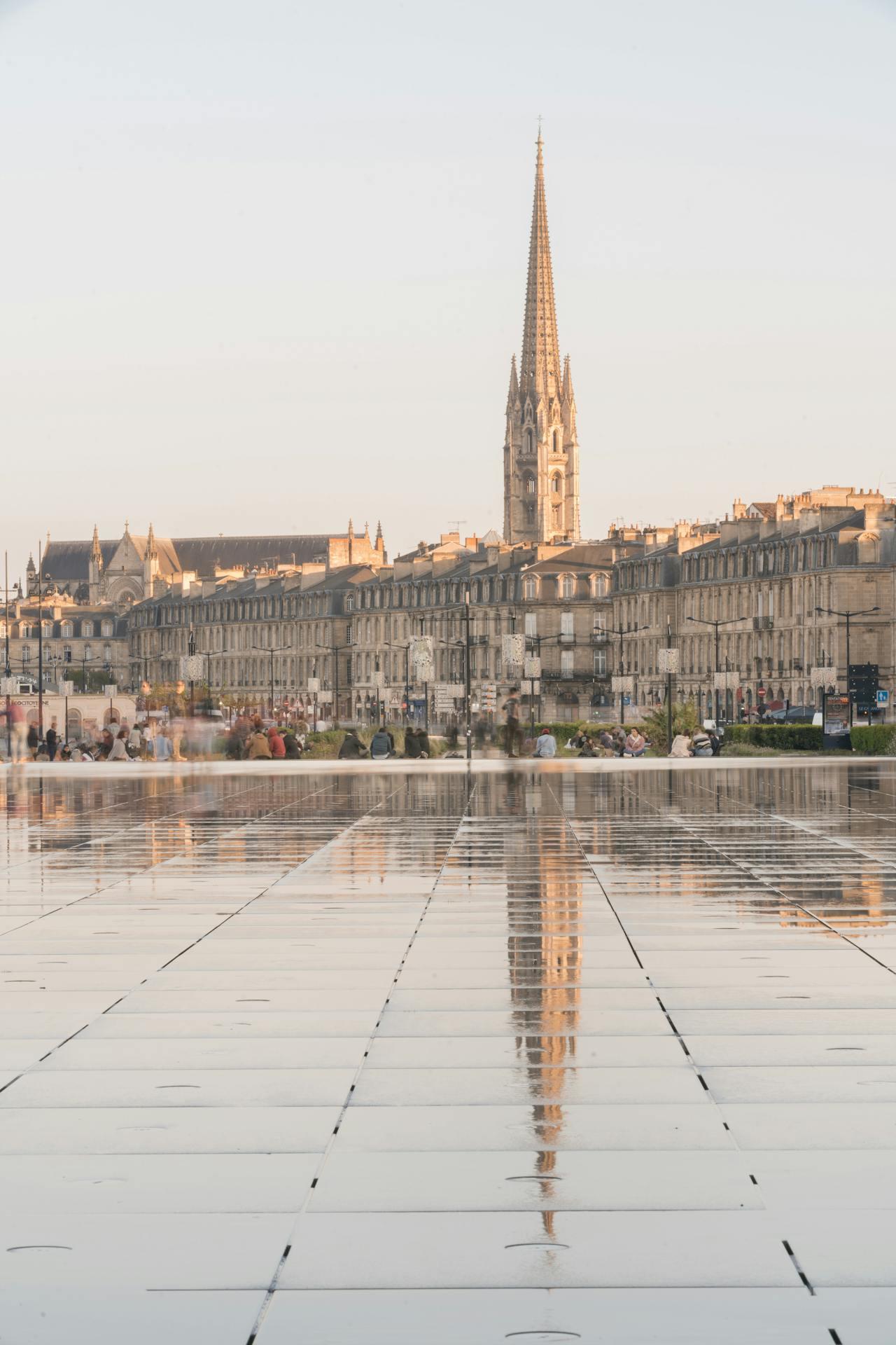 Photo du miroir d'eau avec la flèche Saint-Michel de Bordeaux en arrière-plan.