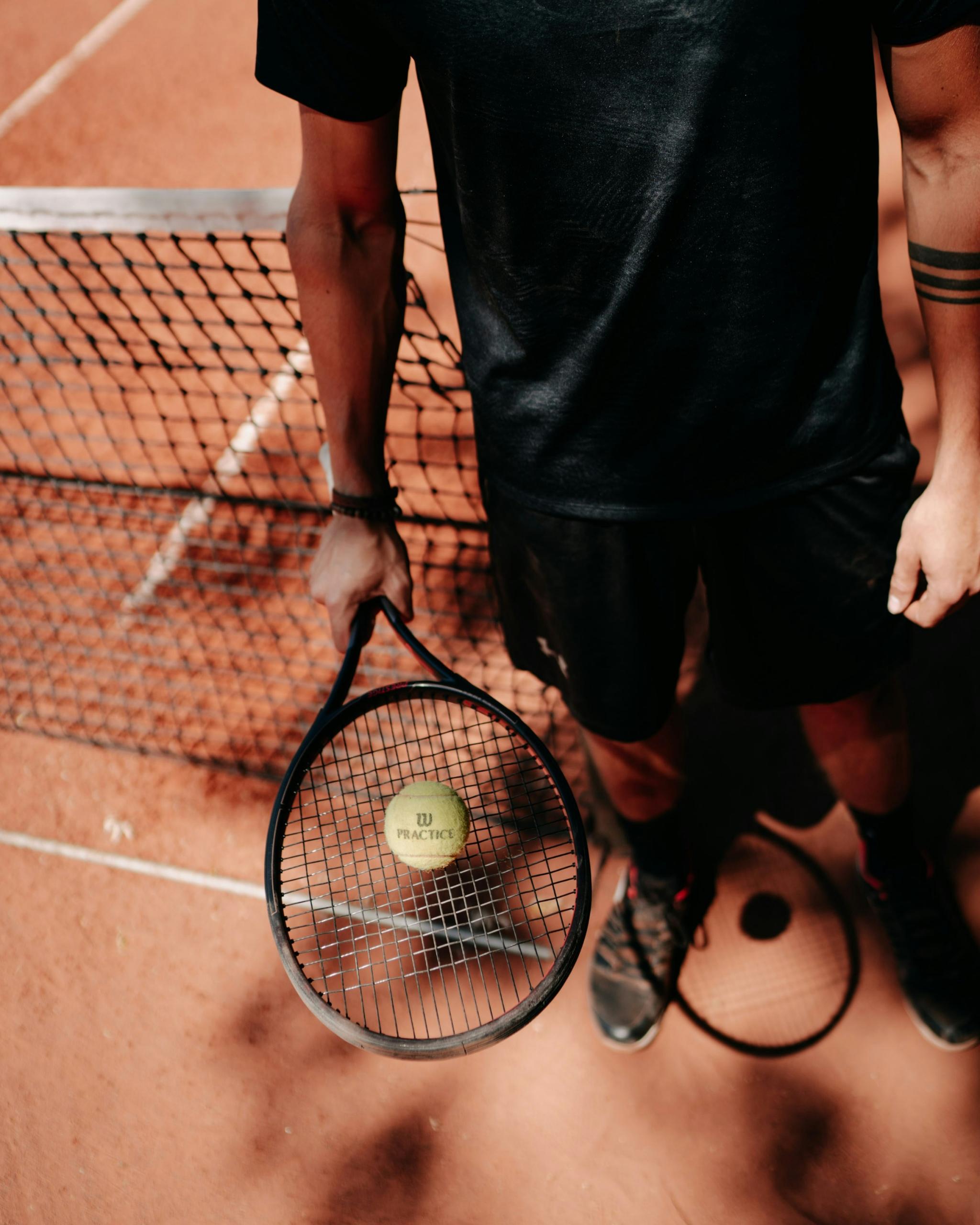 Une basse de tennis posée sur une raquette.
