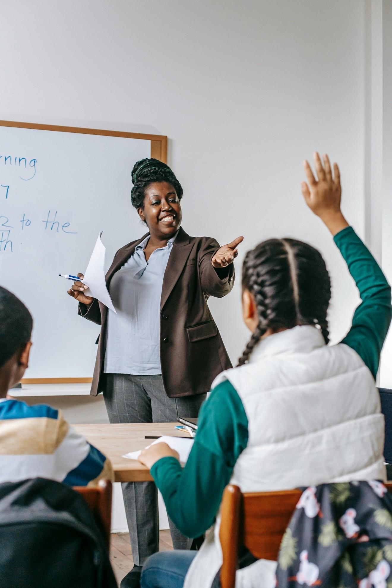Une institutrice en train de questionner une élève.