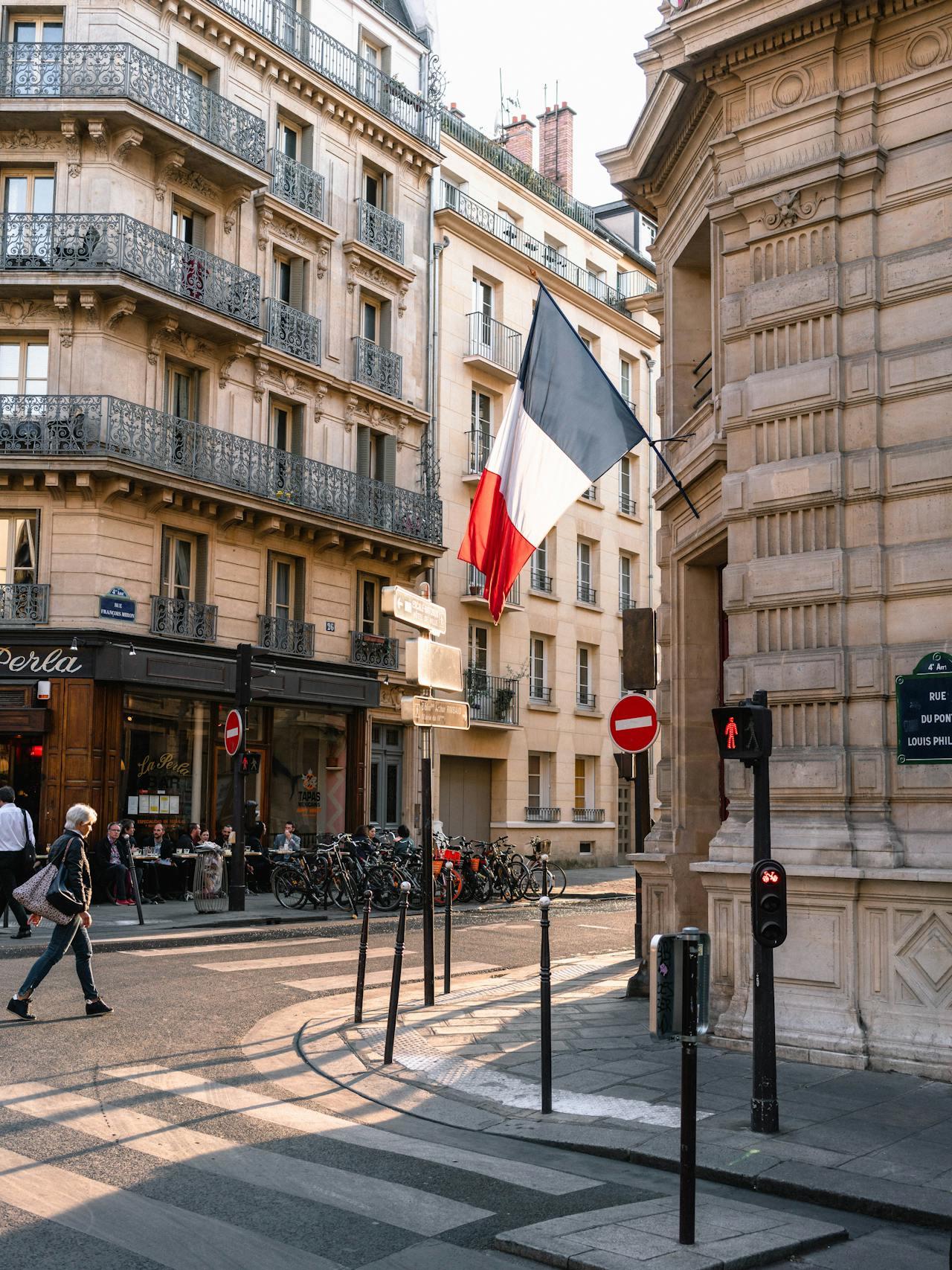 Rue parisienne avec le drapeau français ouvert.