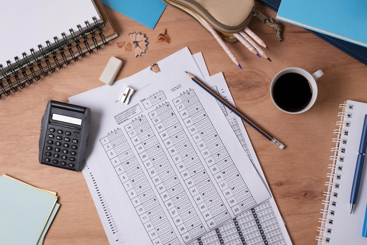 Des feuilles, des stylos et d'autres éléments sont posés sur un bureau.