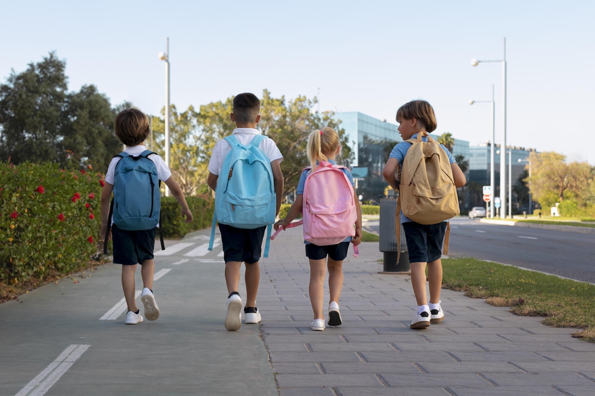 Des enfants vont à l'école avec leur sac à dos