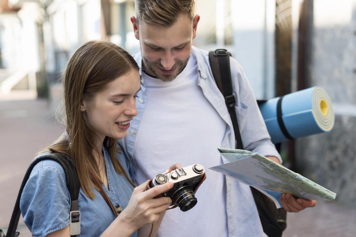 Un couple en voyage regarde ensemble sur un appareil photo.