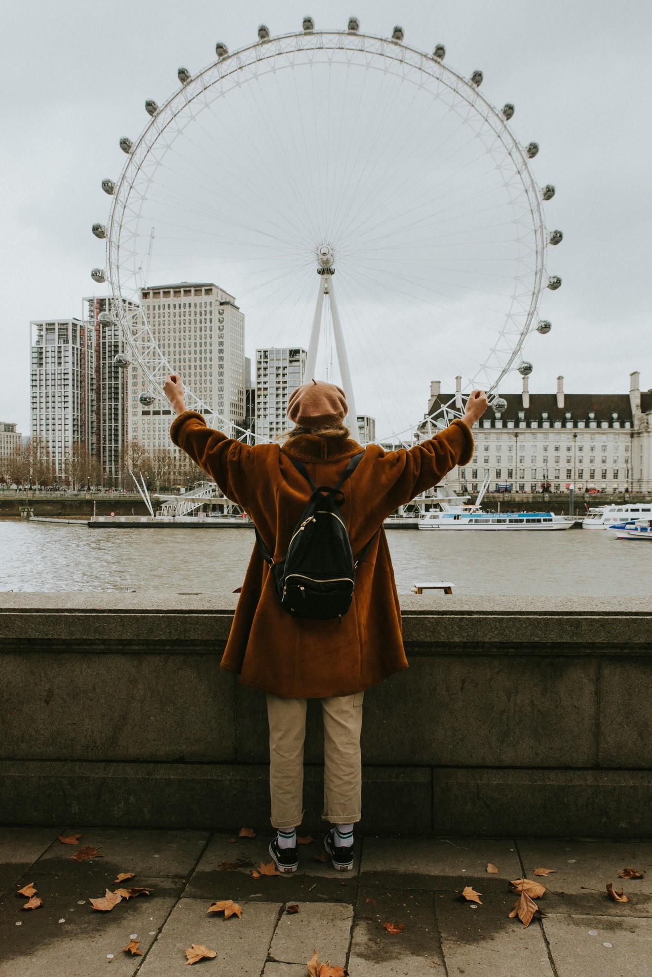Une femme devant une grande roue.
