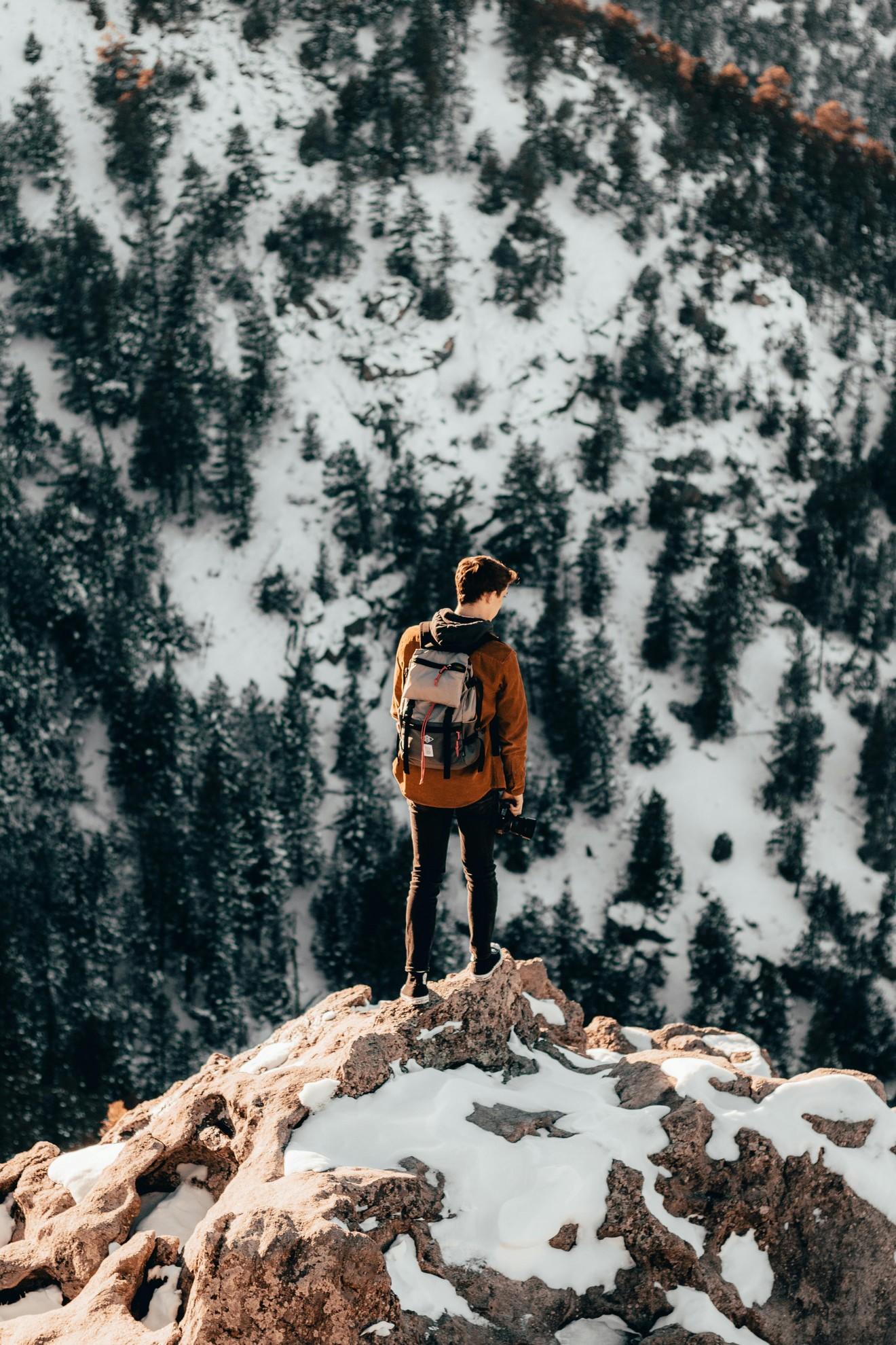 Un jeune homme au sommet d'une montagne.