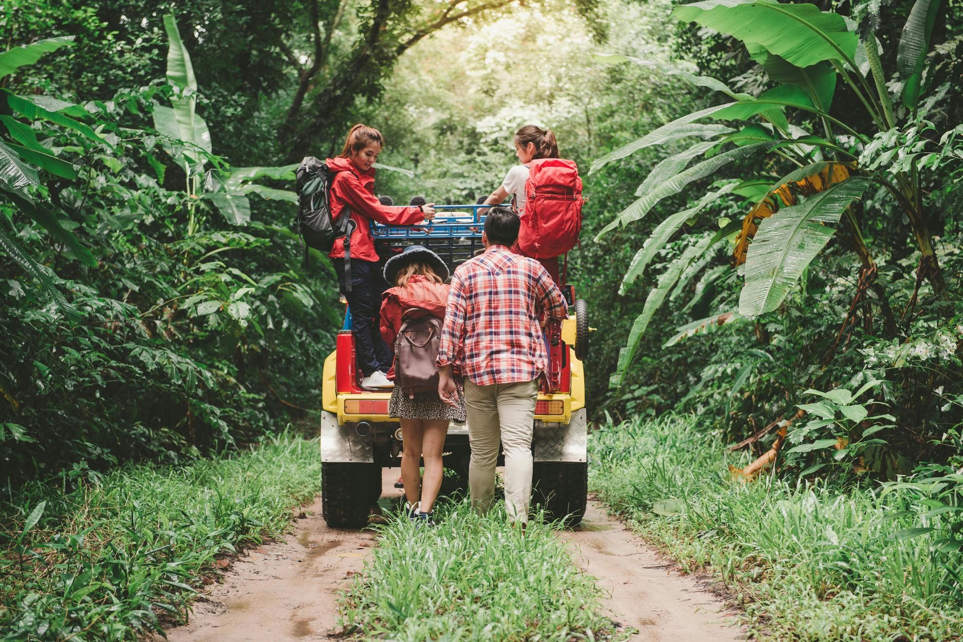 Des personnes à l'arrière d'un véhicule dans la jungle.