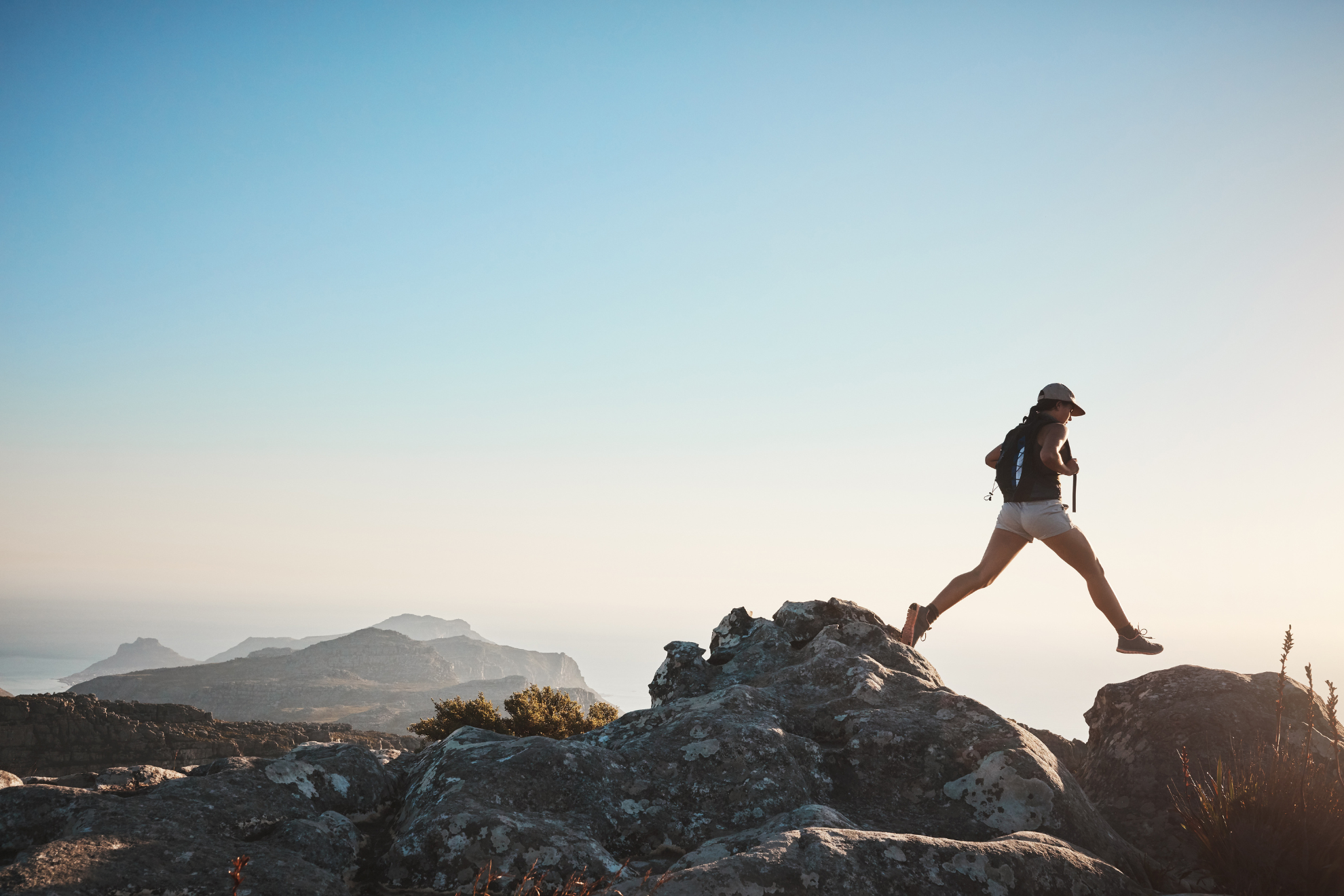 Une femme en train de gravir une montagne.