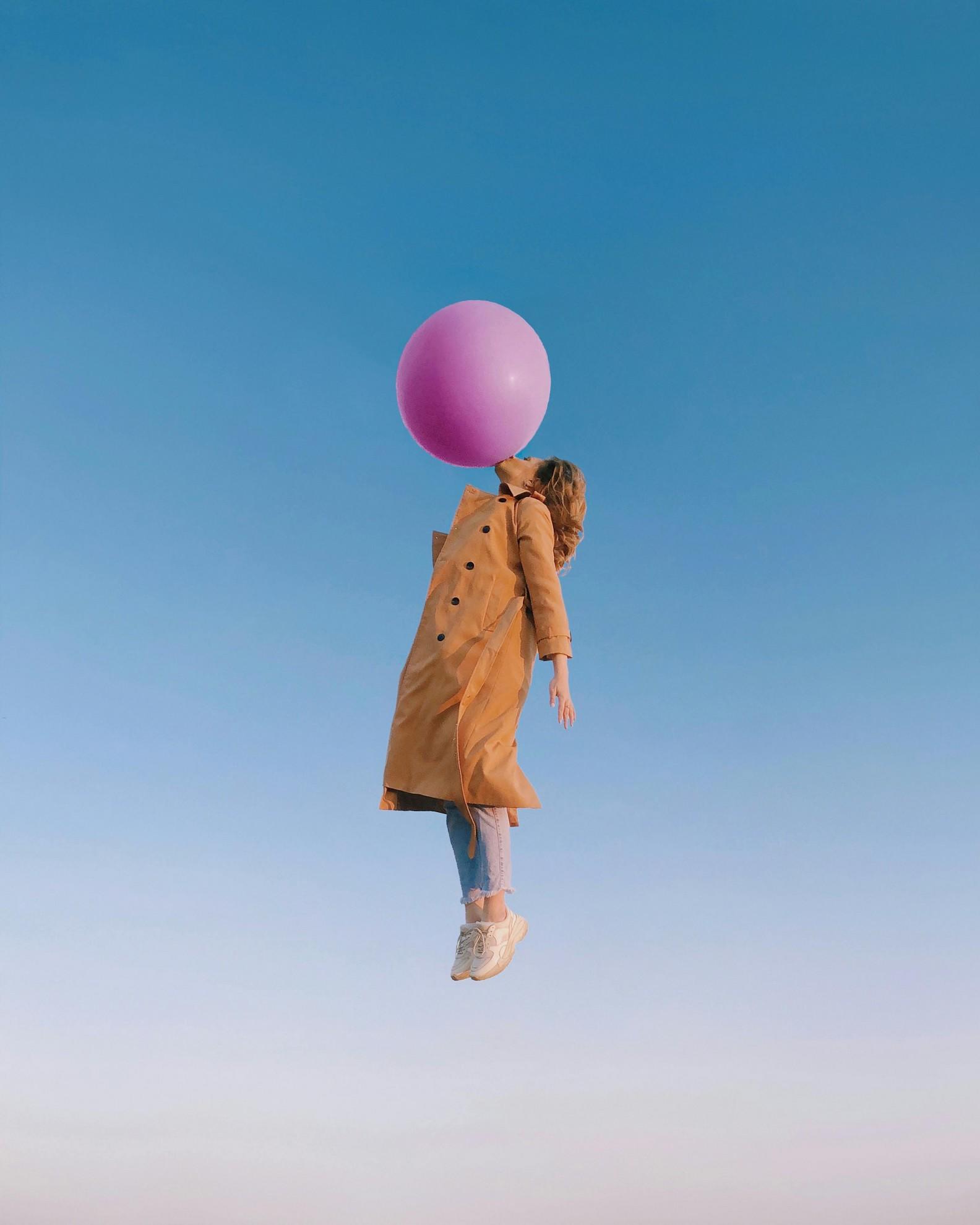 Une femme qui s'envole à l'aide d'une bulle de chewing-gum.