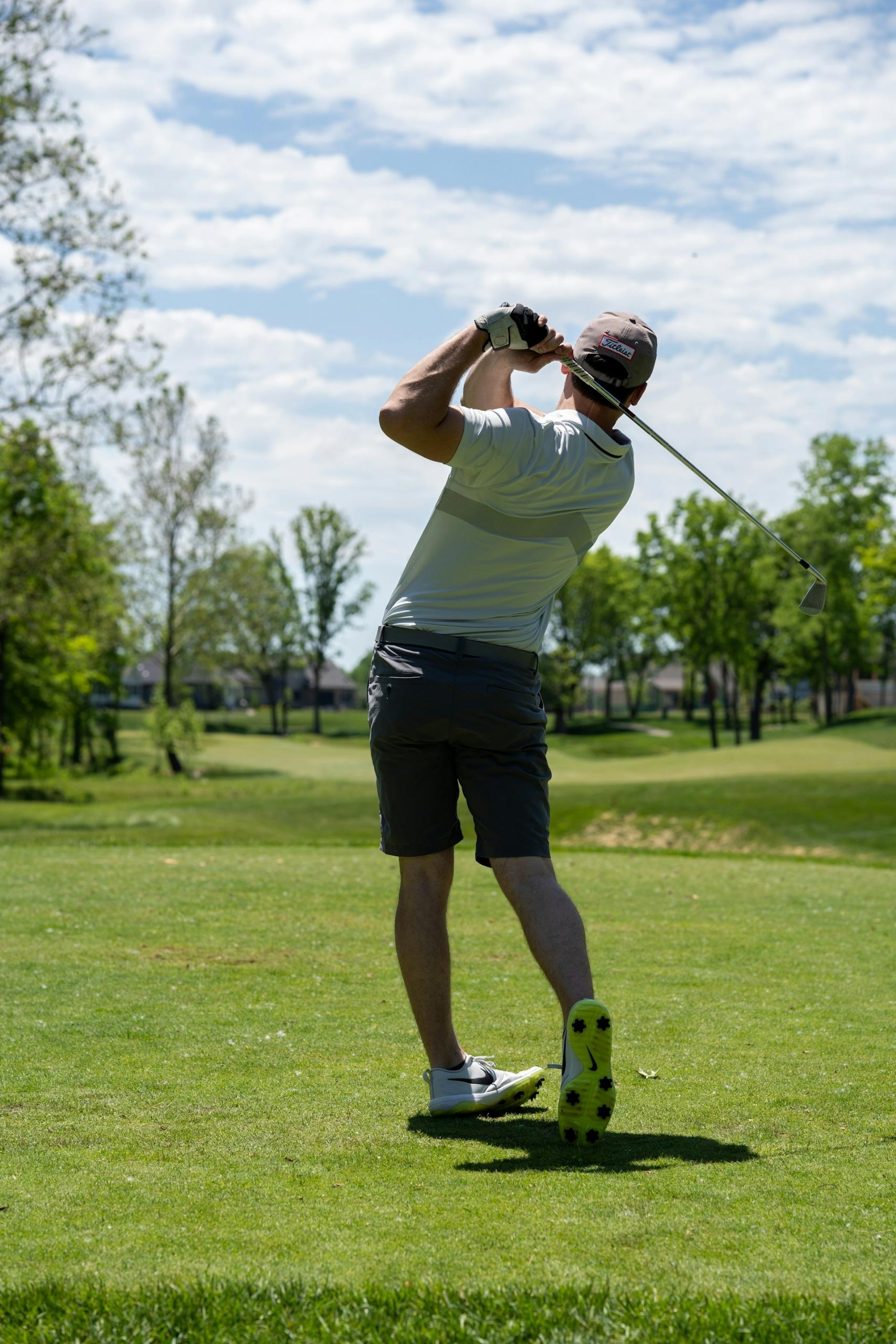 personne en train de swinguer au golf