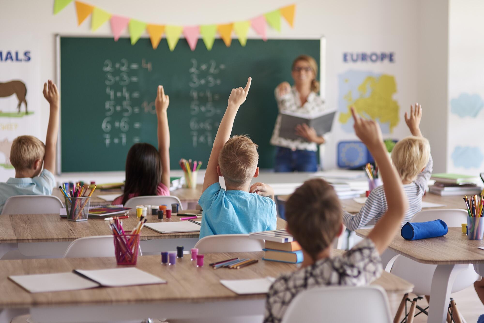 Une classe d'élèves de primaires lève le doigt.