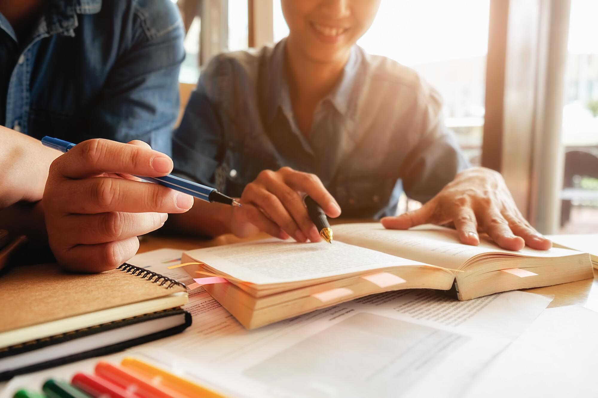 Un jeune homme fait ses devoirs avec une autre personne