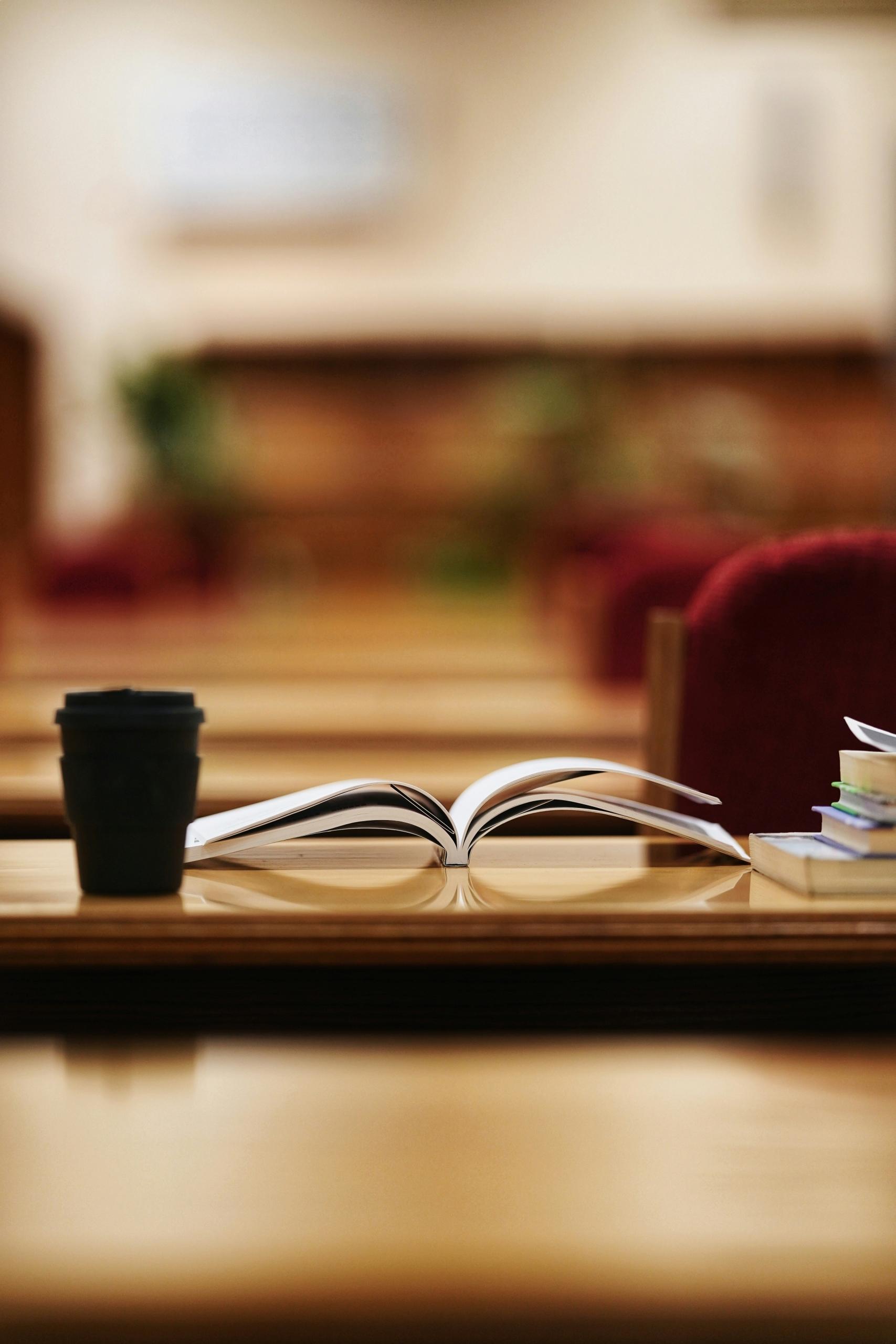 Un livre ouvert posé sur une table de bibliothèque.