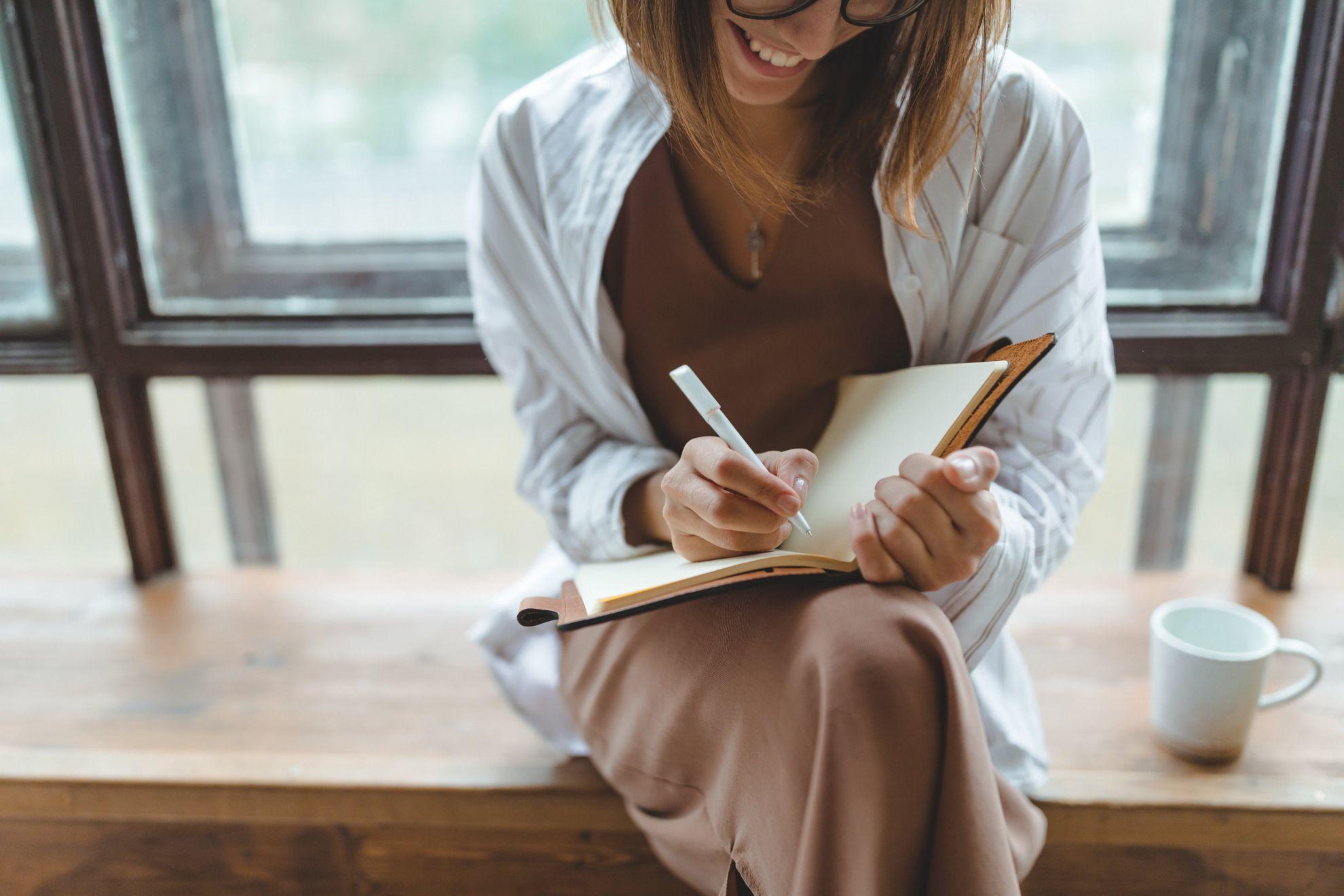Une femme en train d'écrire dans un carnet de notes.