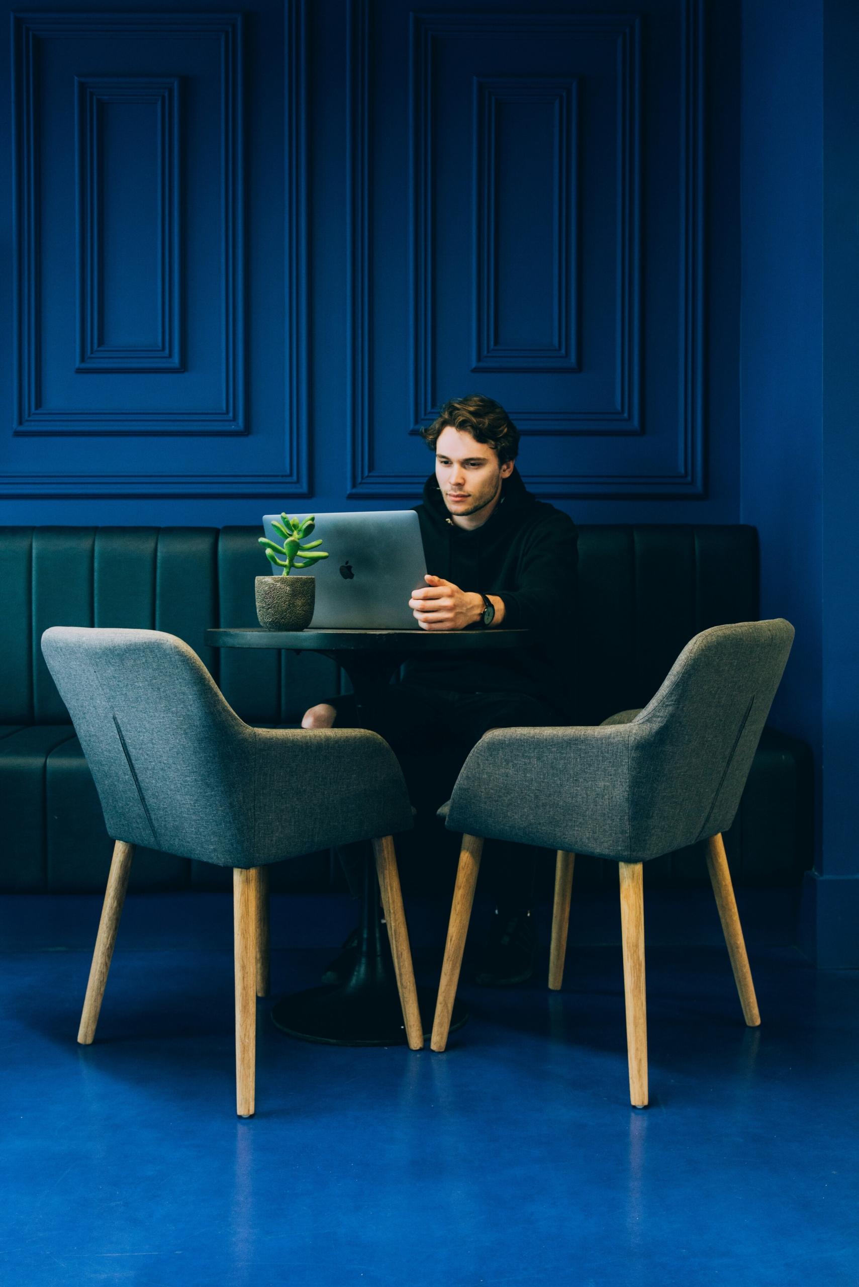 Un étudiant consulte son ordinateur sur un table.