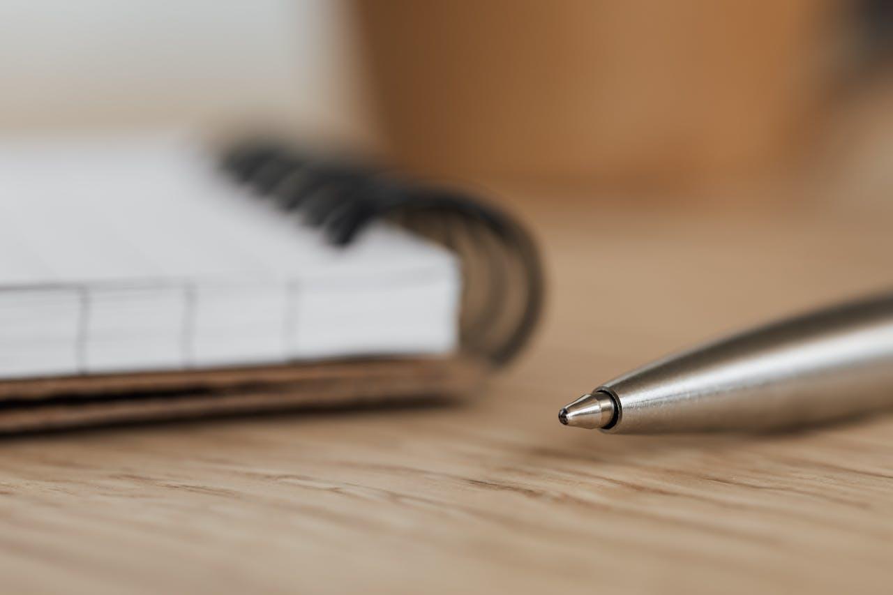 Un stylo et un carnet à spirales ouvert. 