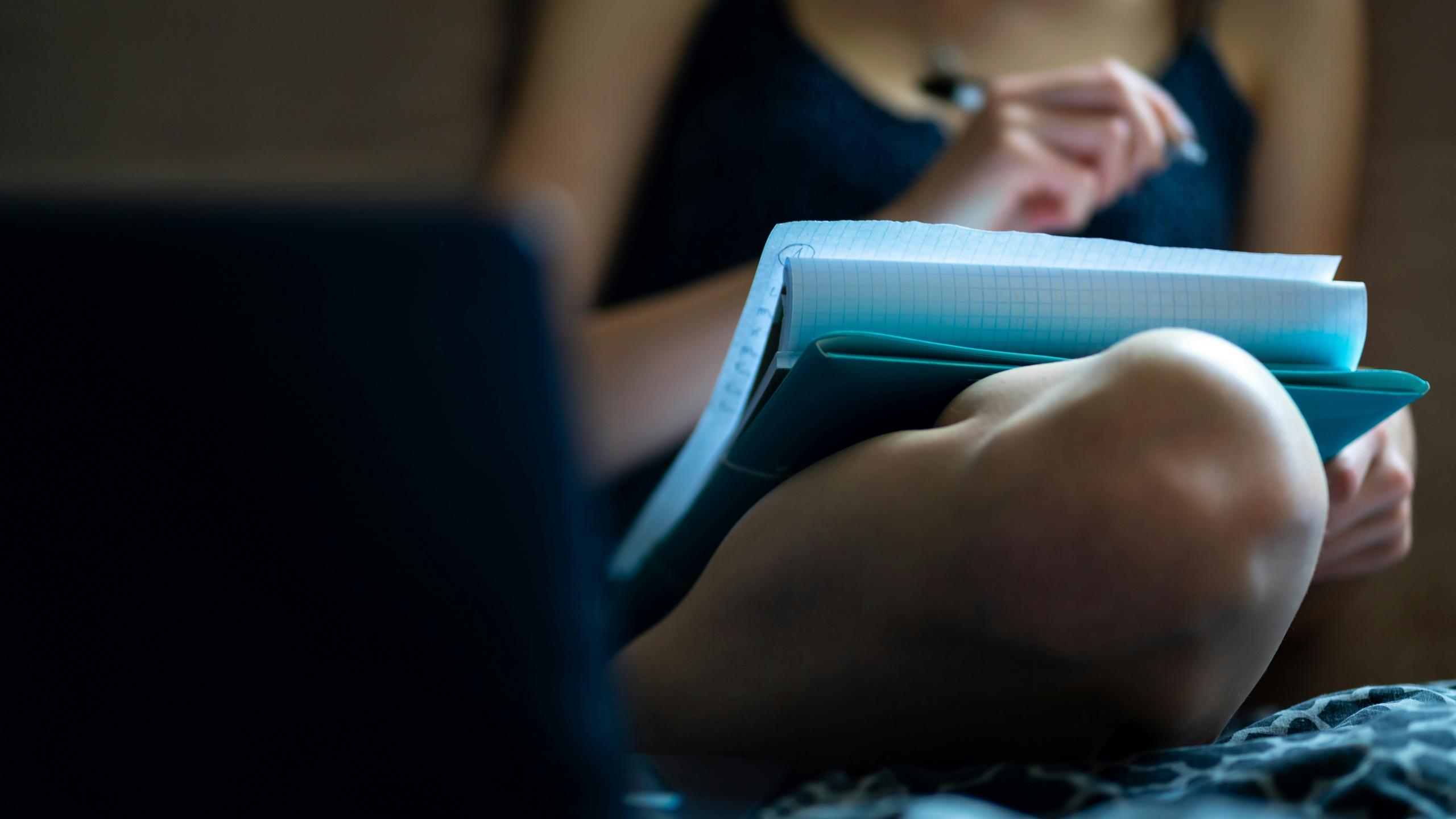 Une doctorante cherche un sujet sur son cahier.