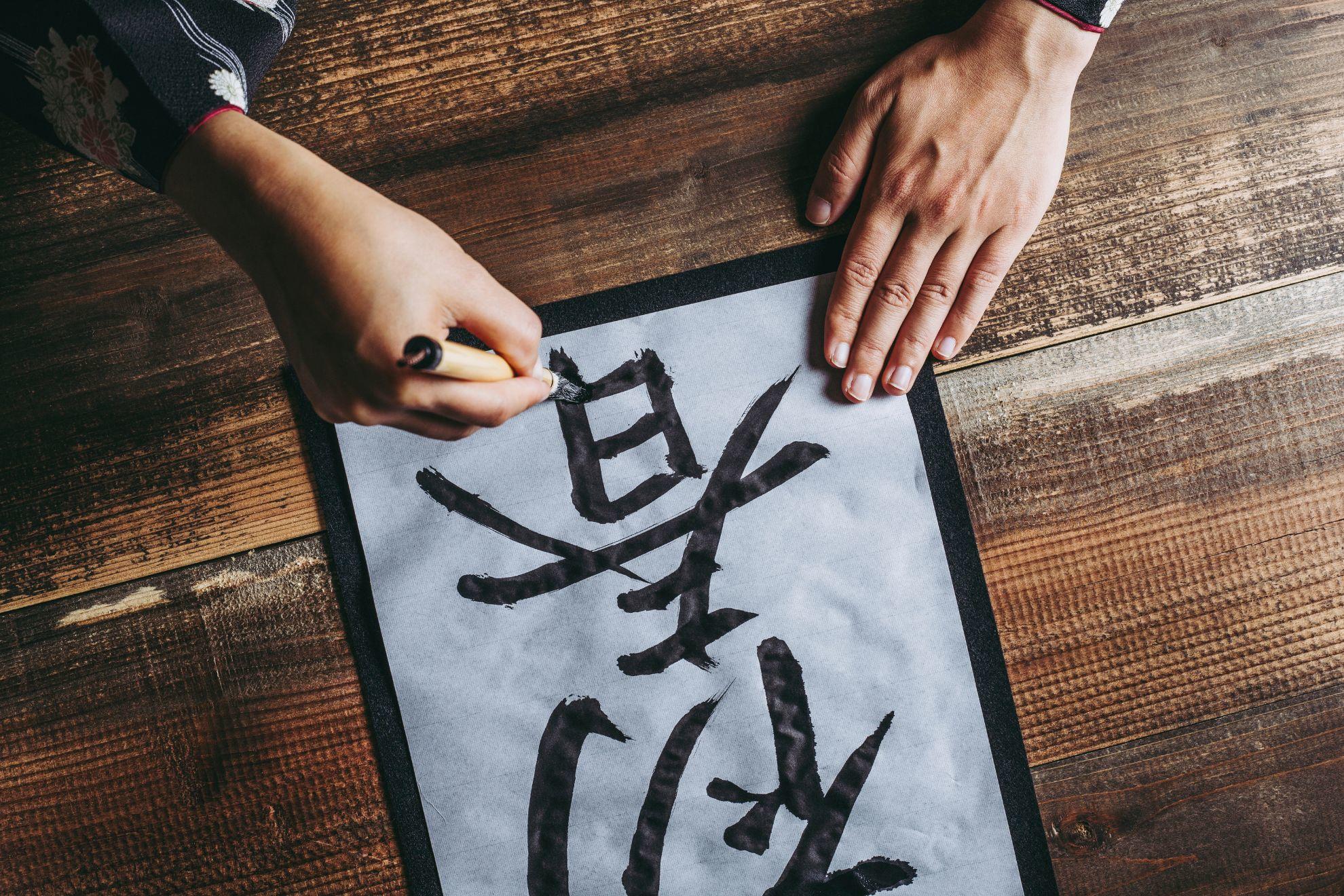 Une personne en train de faire de la calligraphie traditionnelle.