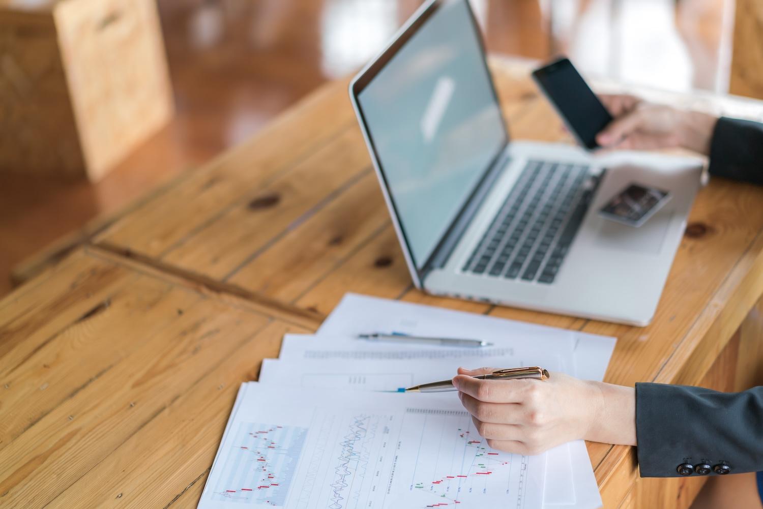 Une personne est sur son ordinateur et fait de la finance.