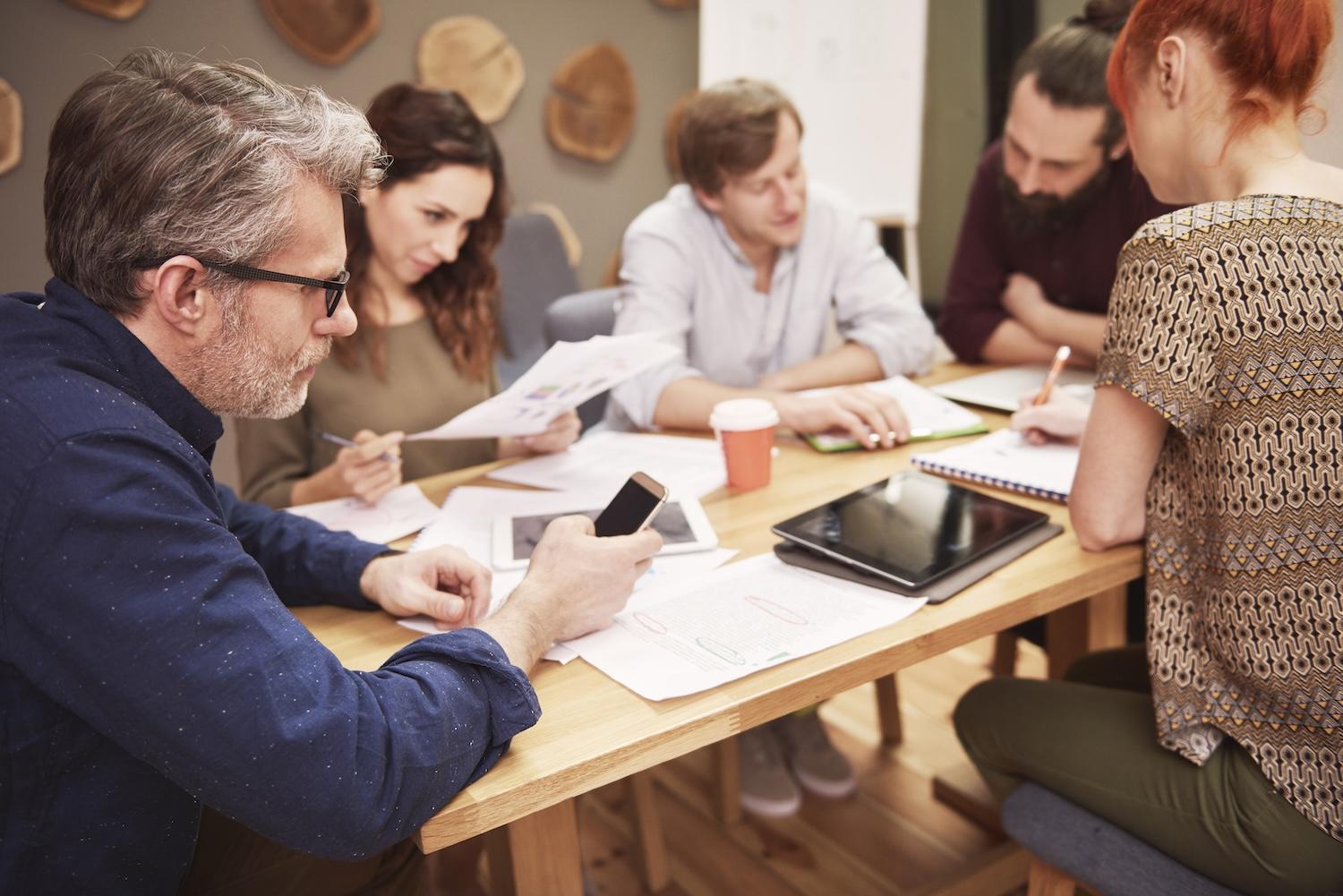 Un groupe de personne travaille ensemble sur une table.