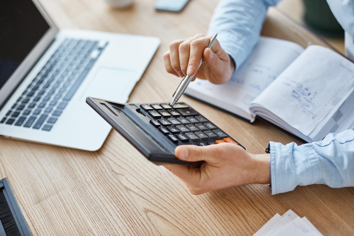 Un homme est en train de calculer sur une calculette.