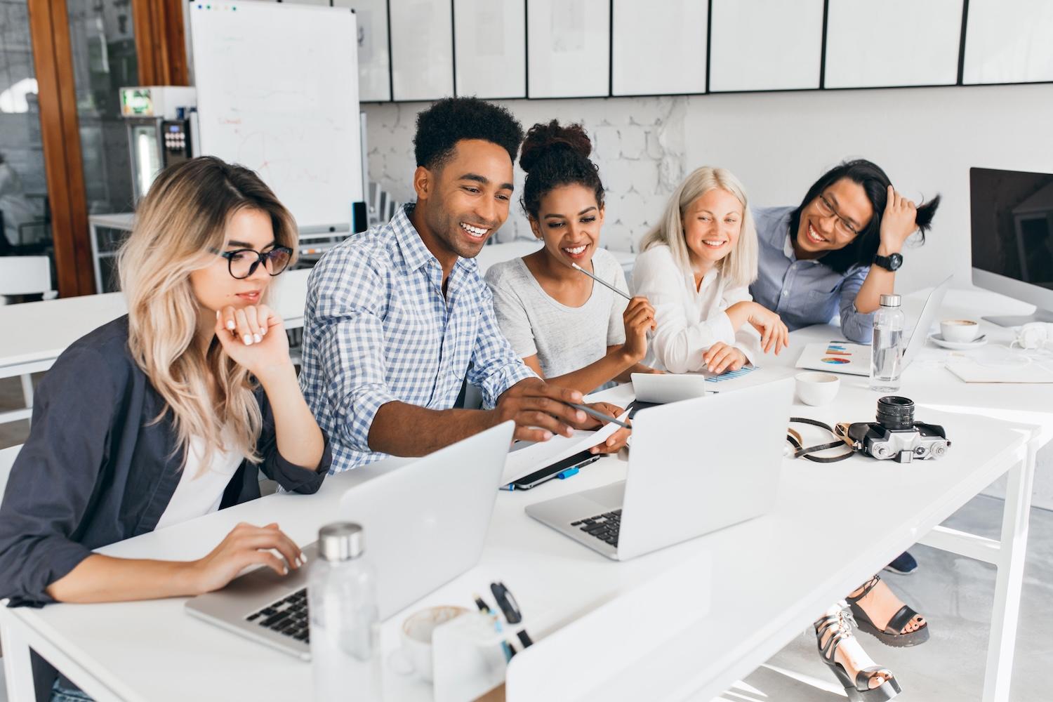 Des étudiants sont sur une table avec leur ordinateur.