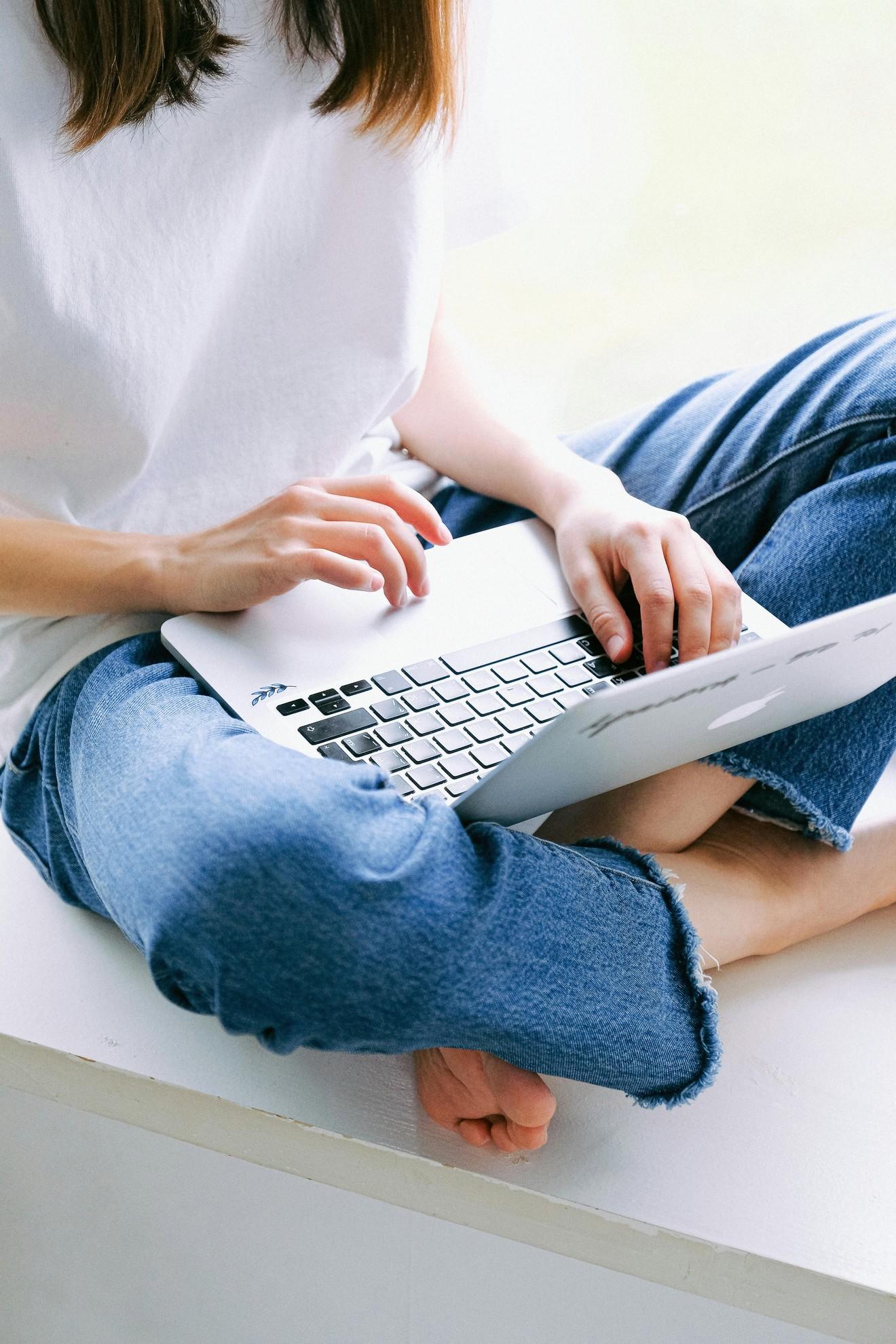 Une personne en train de pianoter sur son ordinateur portable.