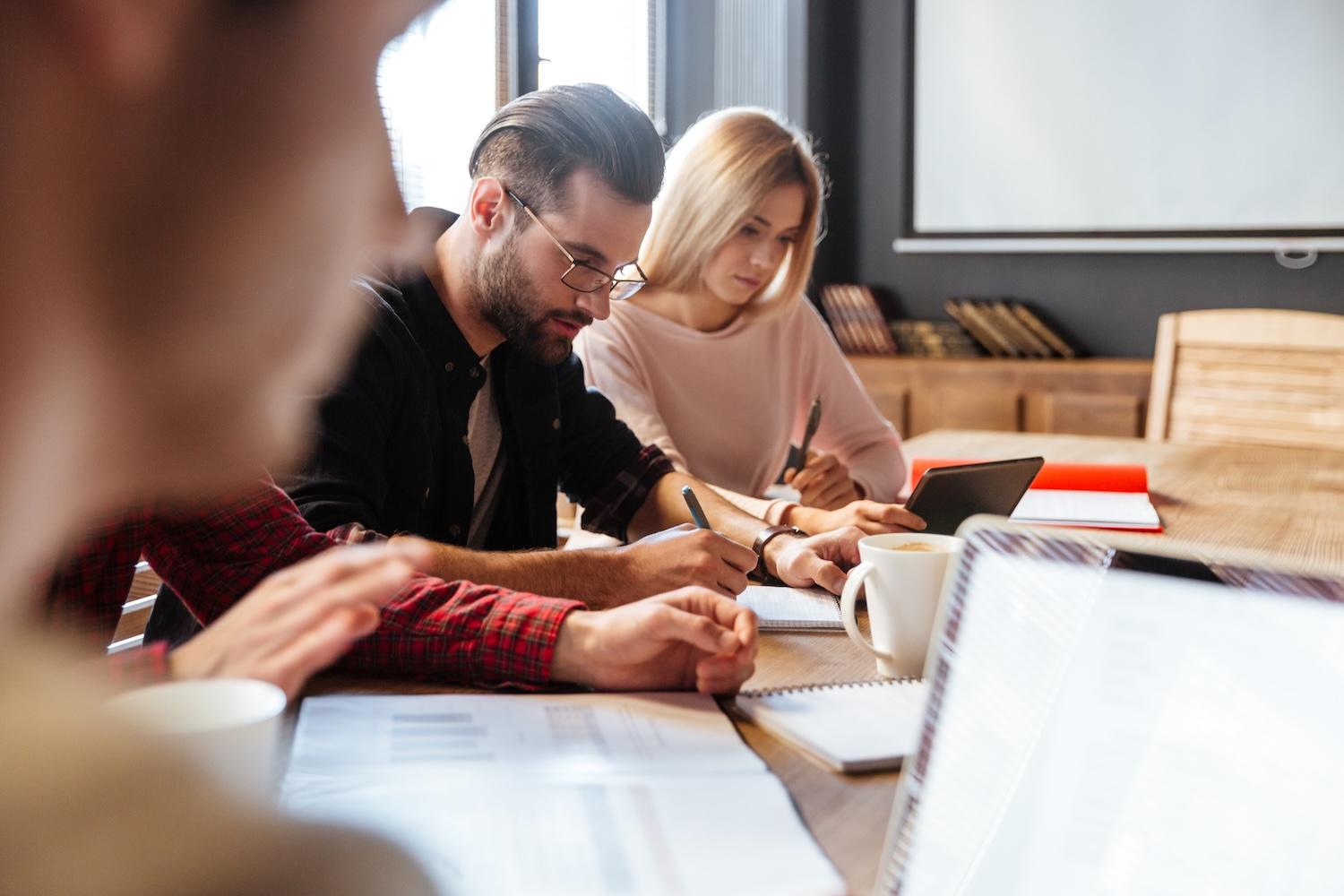 Quelques étudiants sont assis à une table en train d'étudier.