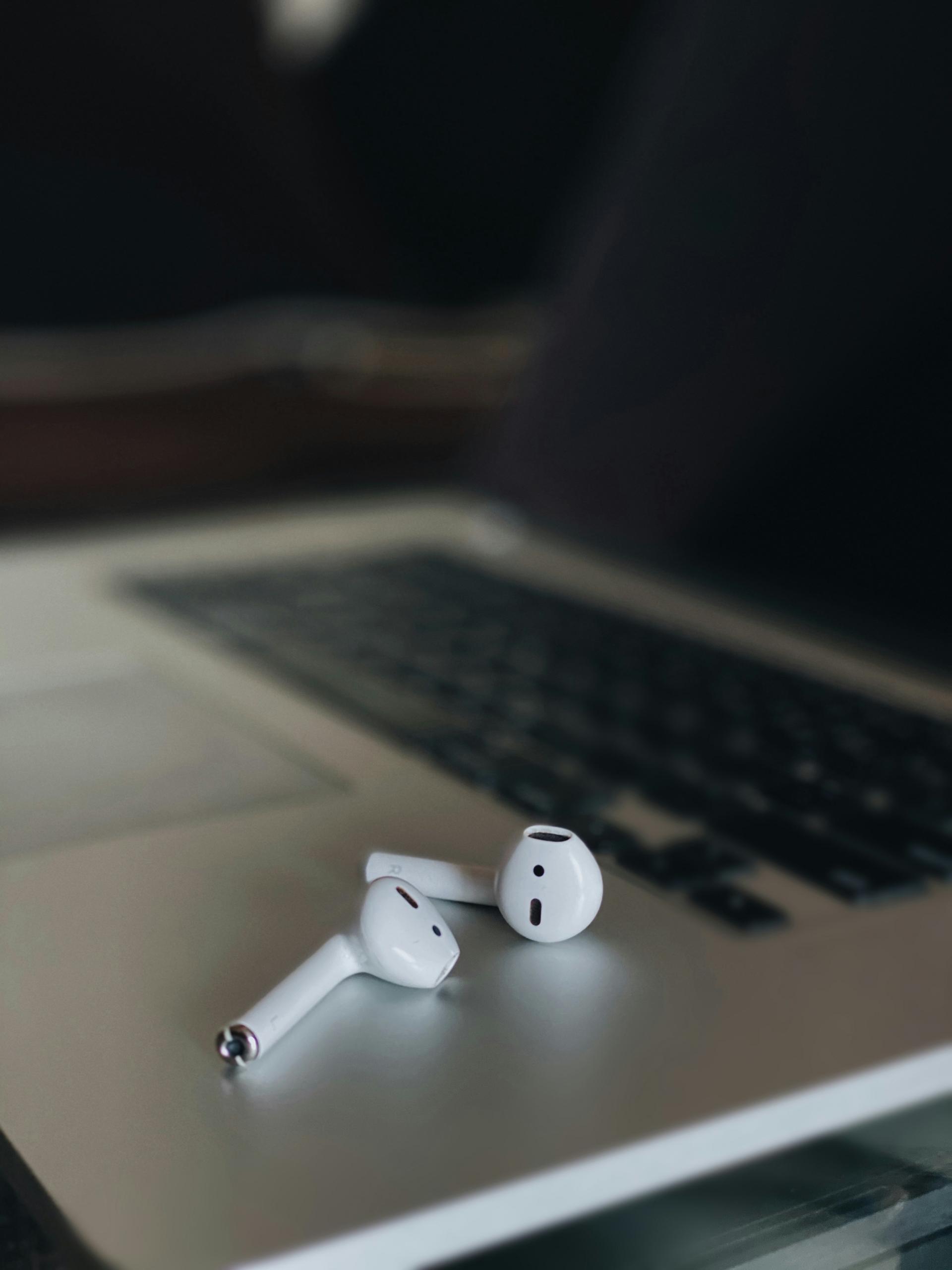 Des Airpods posés sur un ordinateur portable.