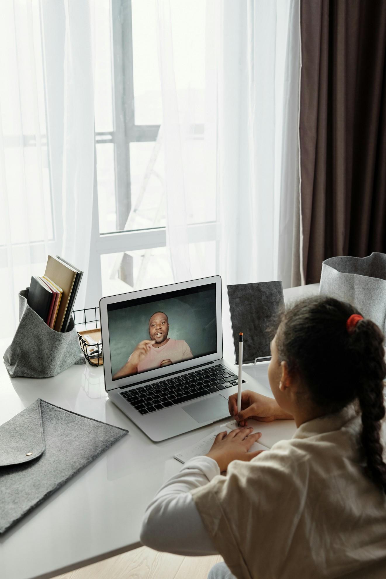 Une petite fille prenant un cours en ligne.