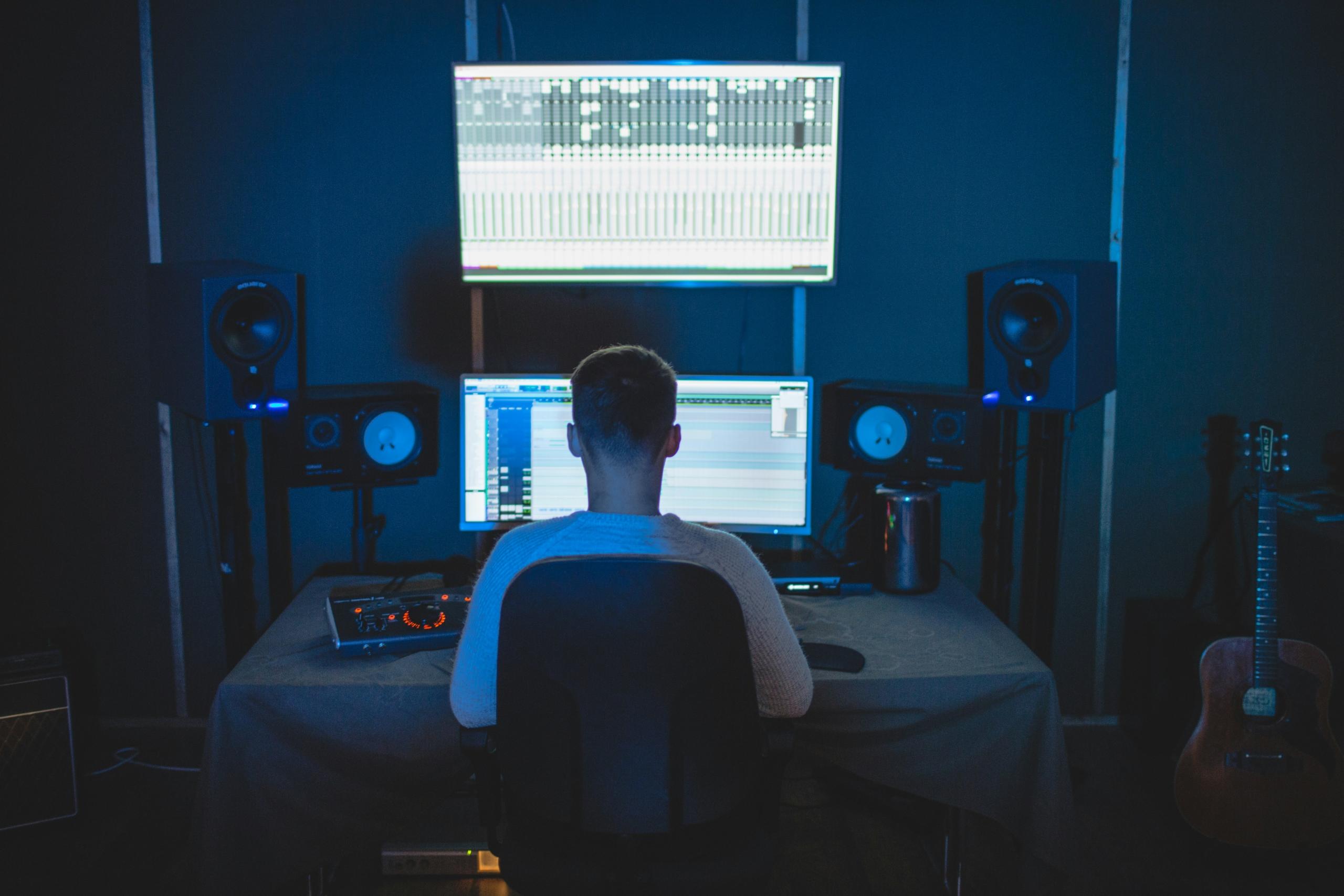 Un homme de dos compose de la musique avec un logiciel.