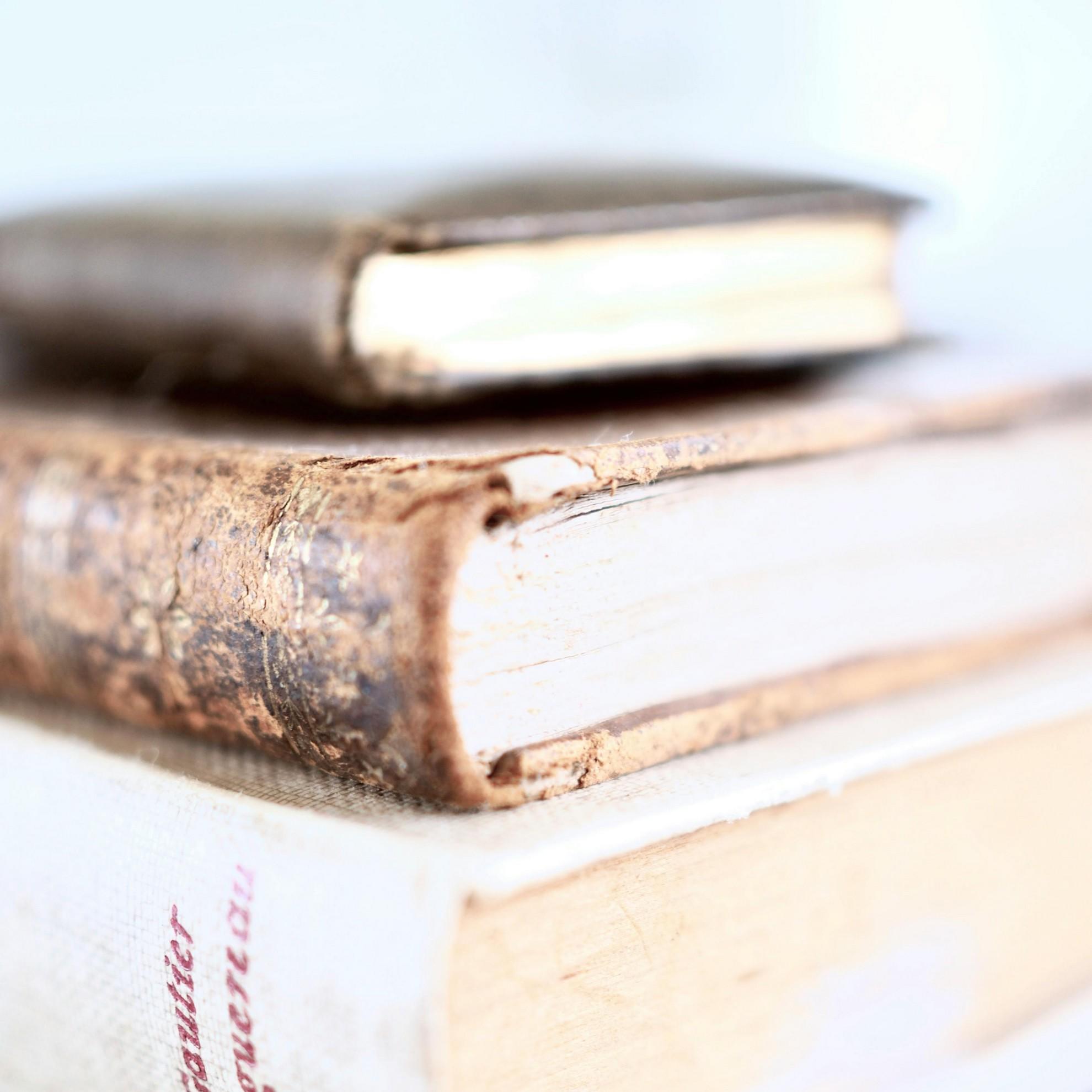 Trois livres anciens empilés.