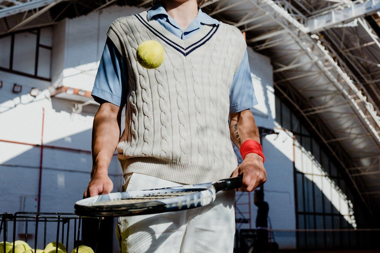 Homme faisant rebondir une balle de tennis sur une raquette.