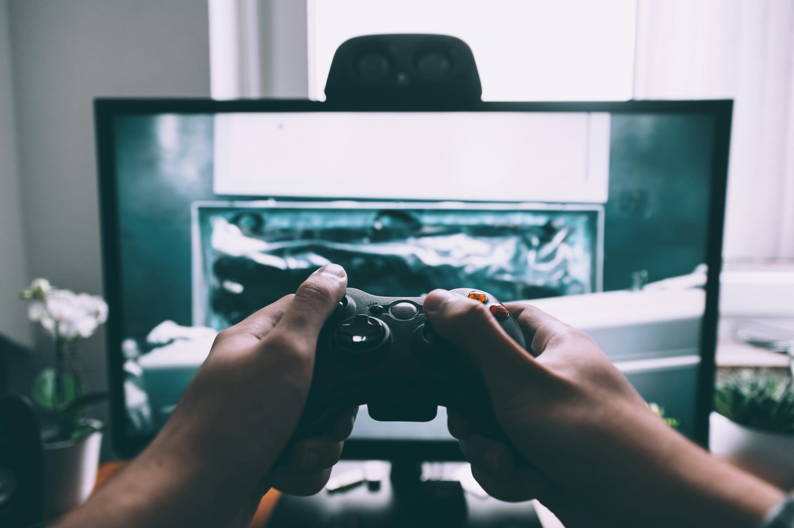Une manette de jeu vidéo devant un écran.