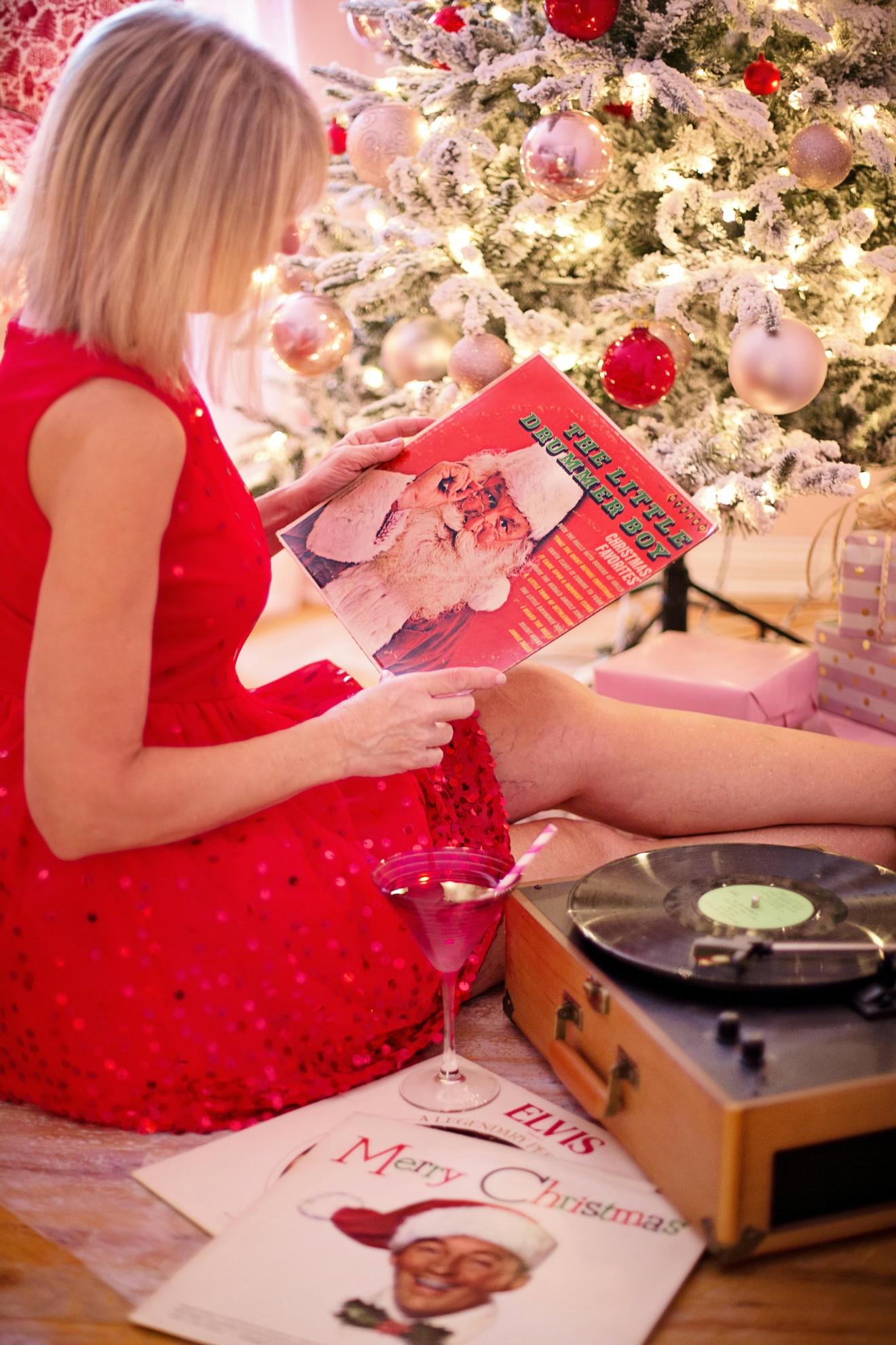 Une femme en train d'écouter des vinyles de Noël.