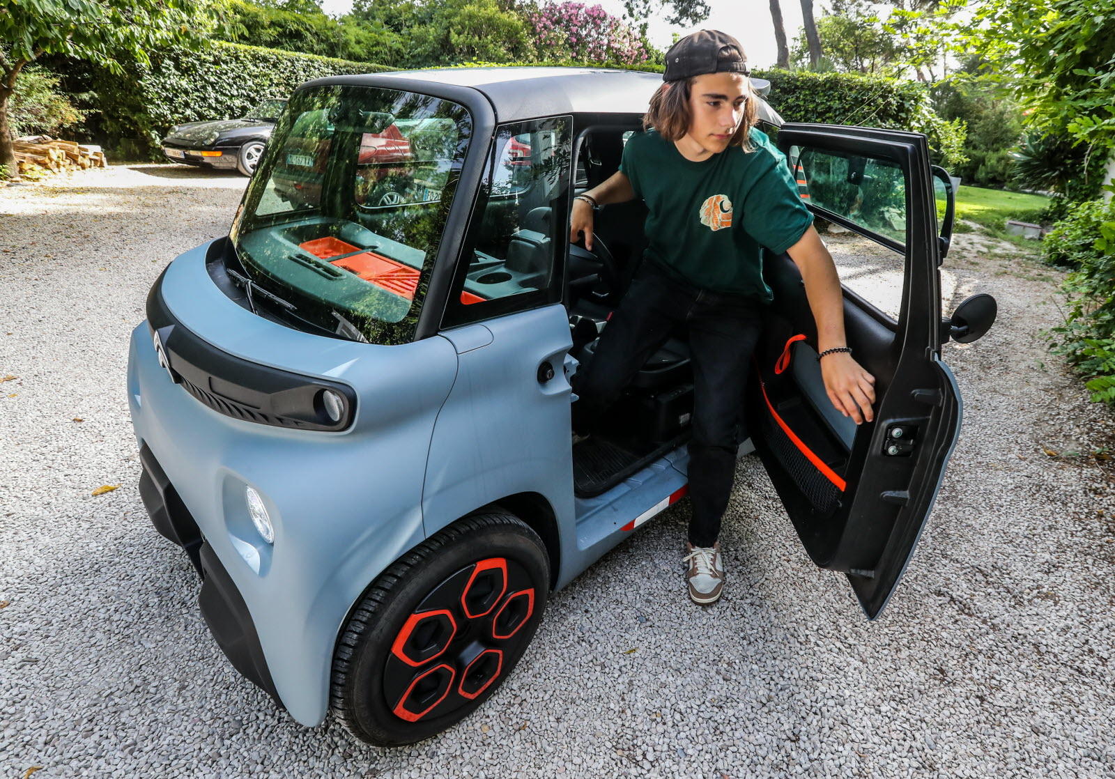 jeune en train de sortir d'une voiture sans permis électrique