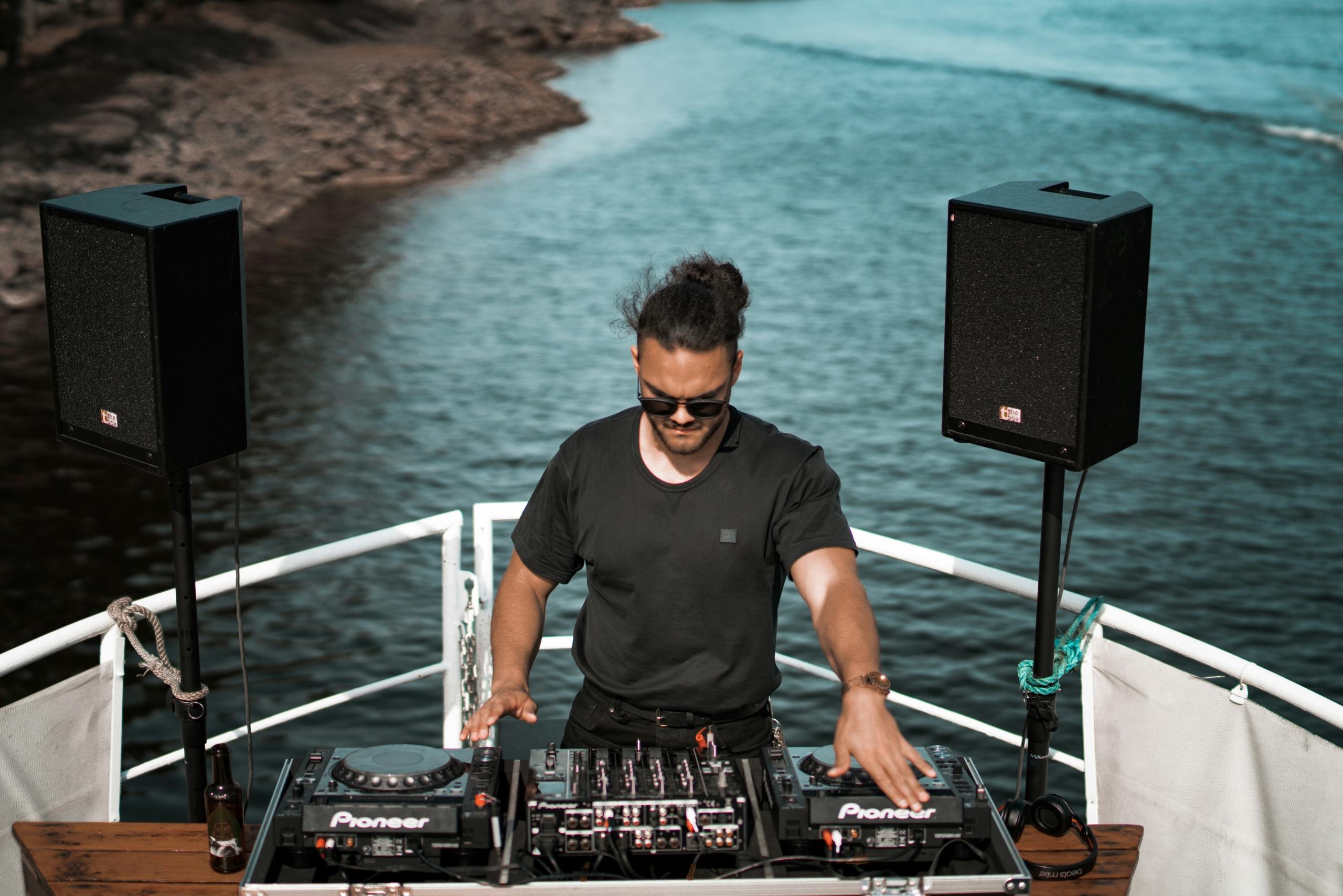Un DJ mixe devant la mer.