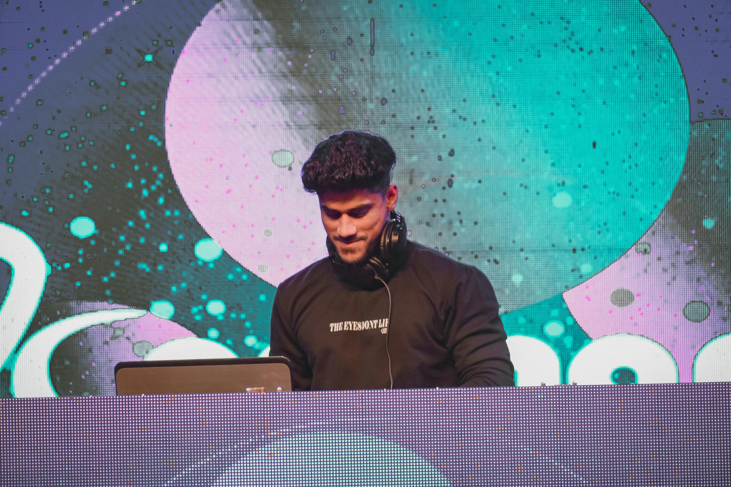 Un DJ mixe dans un festival.