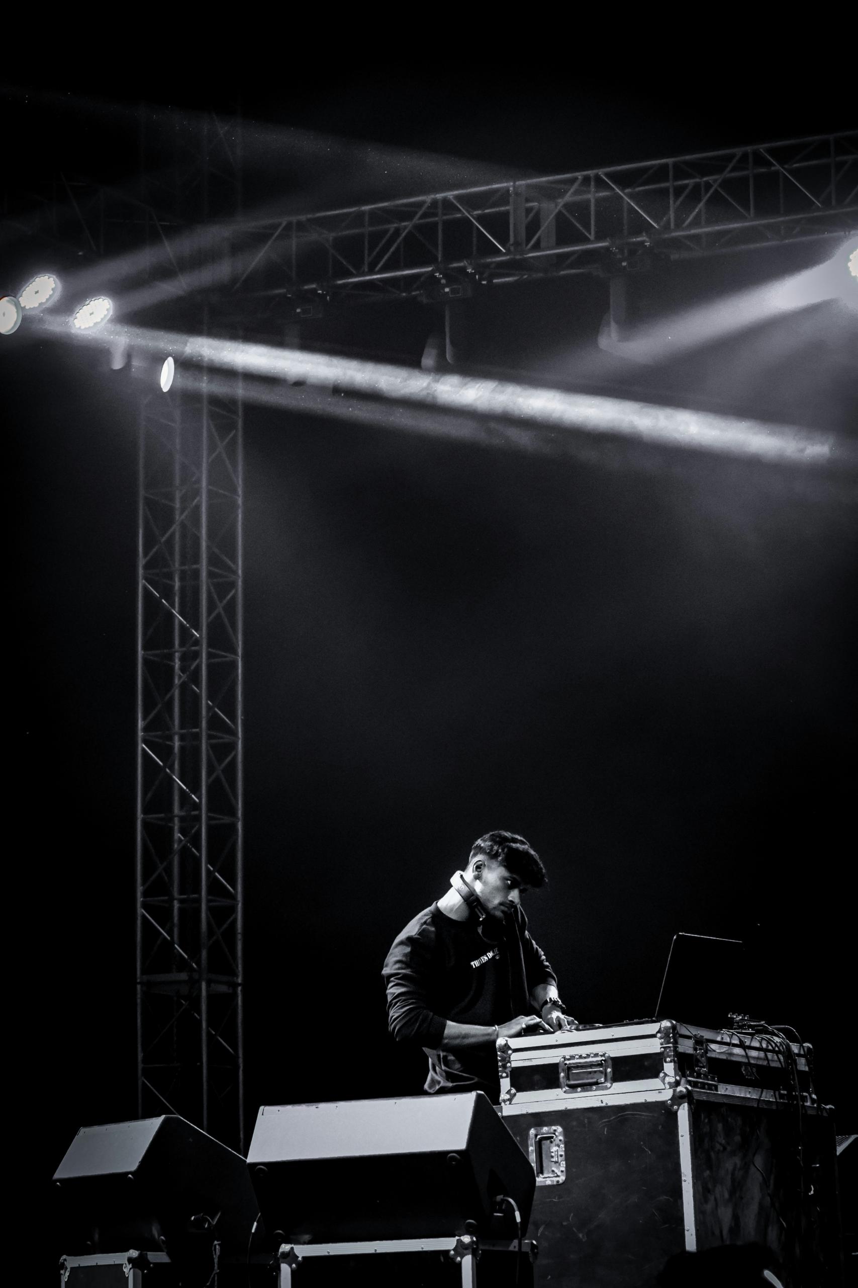 Un DJ mixe au milieu d'une scène.
