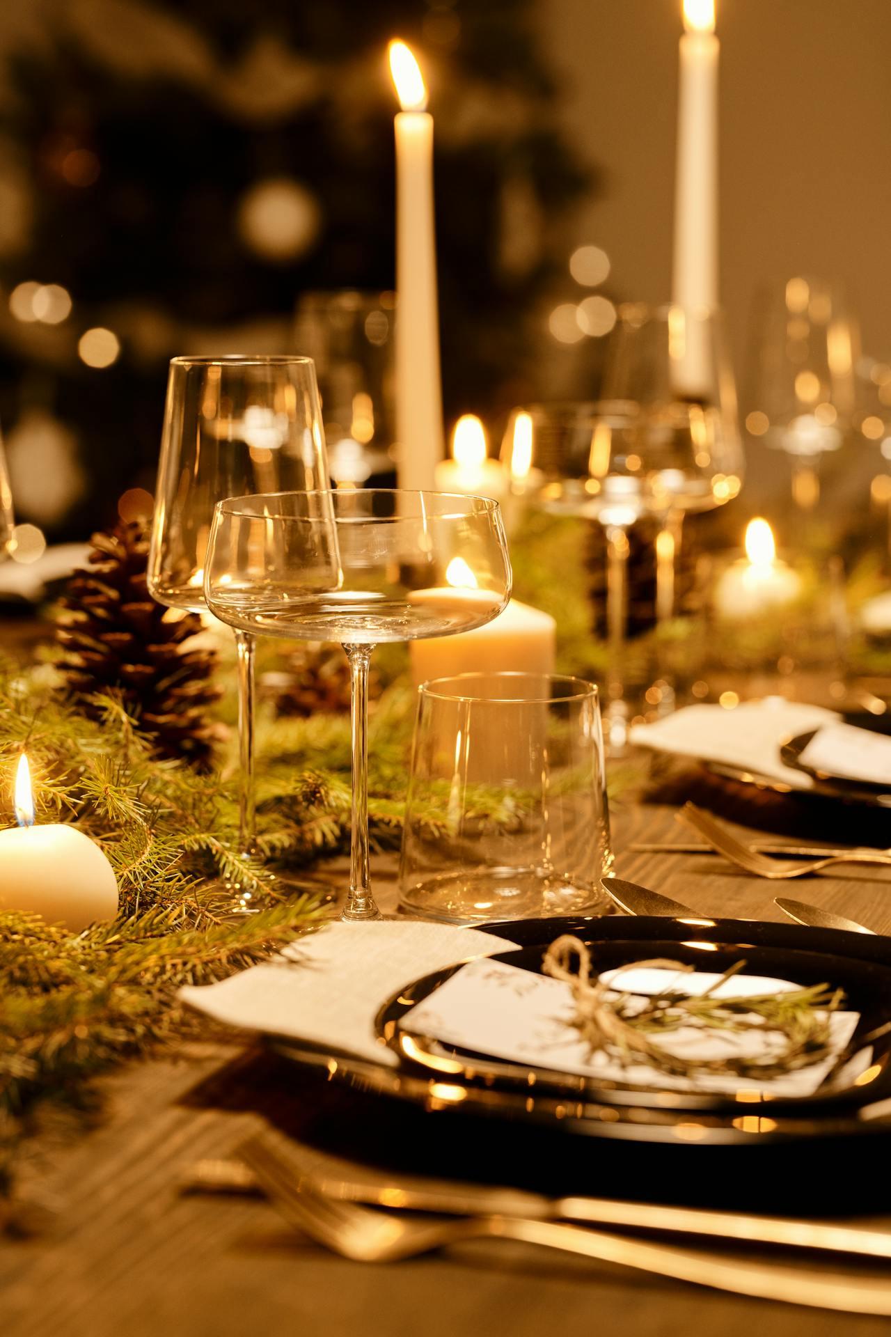 Jolie table de Noël décorée avec des bougies et des branches de sapin. 