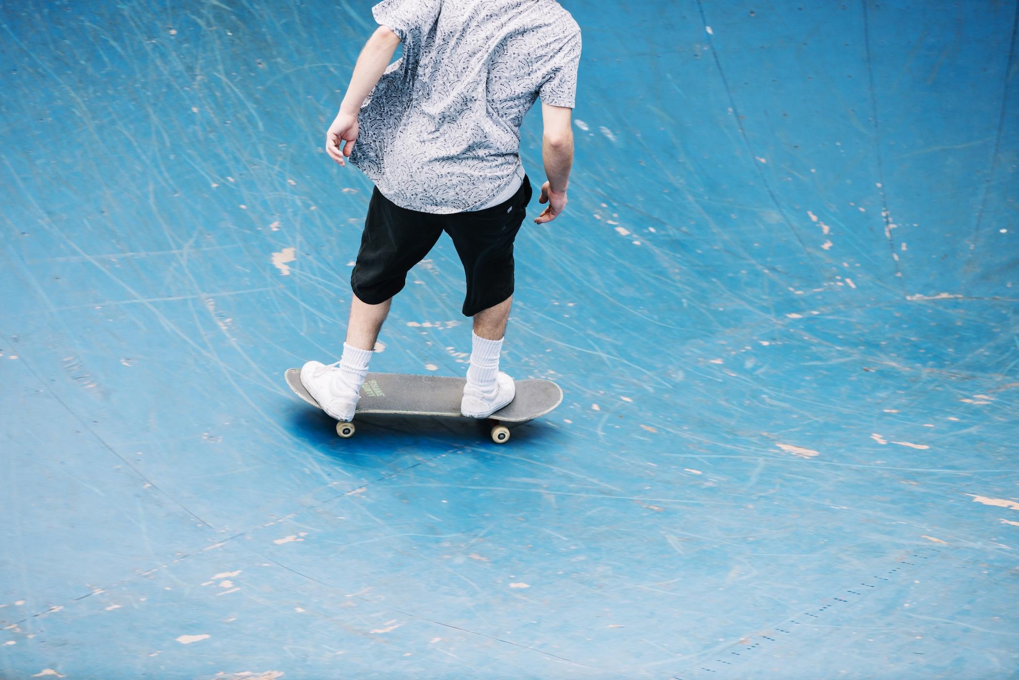 Vue d'un jeune homme de dos en train de skater sur un module.