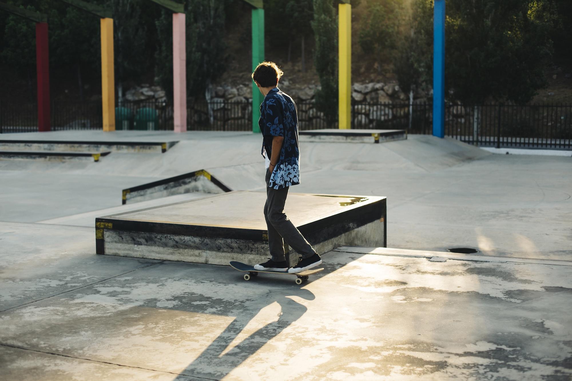 Un jeune homme est en train de faire du skate dans un skatepark.
